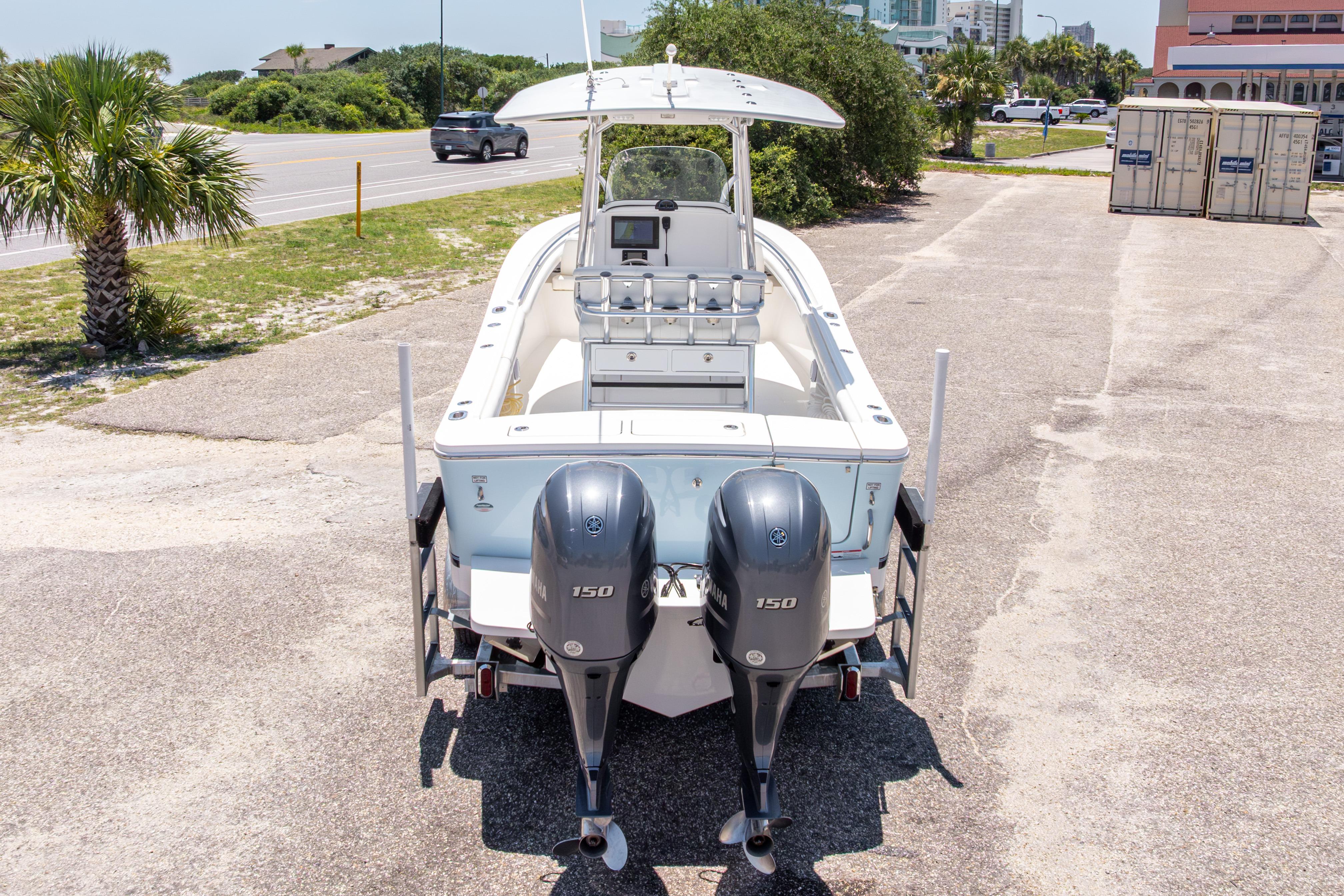 2019 Regulator 23 Center Console boat with dual Yamaha 150 engines, parked outdoors.