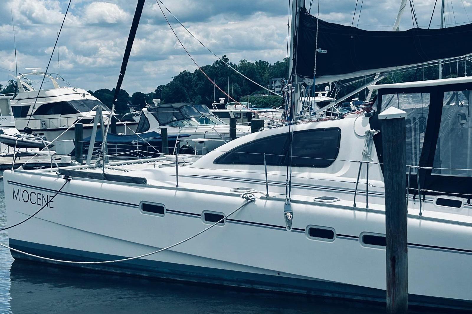 2001 Robertson & Caine Leopard yacht docked at marina under cloudy sky.