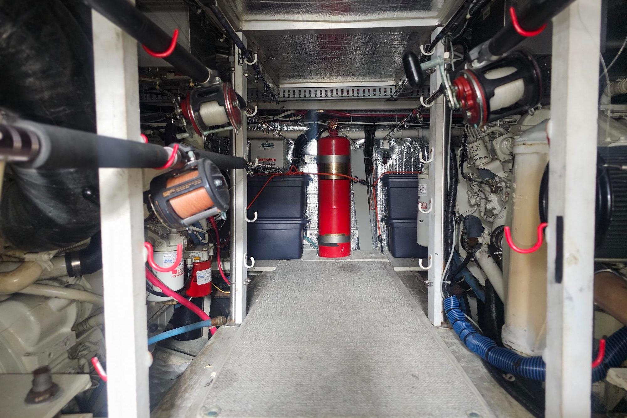 Engine room of 2002 Carver 450 Voyager Pilothouse with fire extinguisher and mechanical components.
