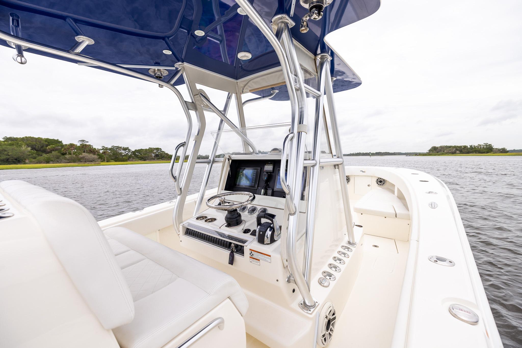 2019 SeaVee 322Z boat cockpit with modern controls and blue canopy on a calm waterway.