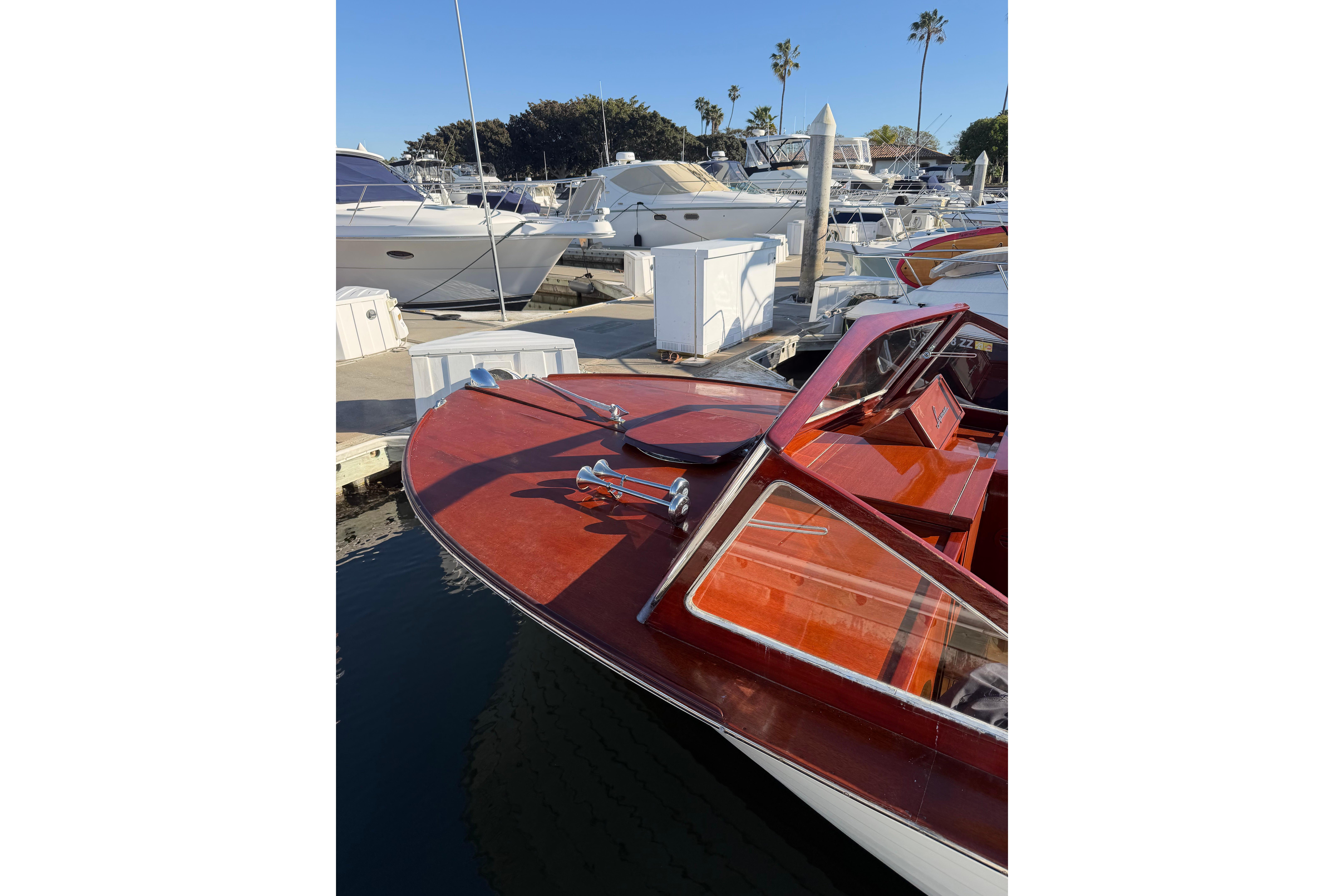 1964 Lyman 25 Sleeper boat docked at a marina, showcasing classic wooden design.