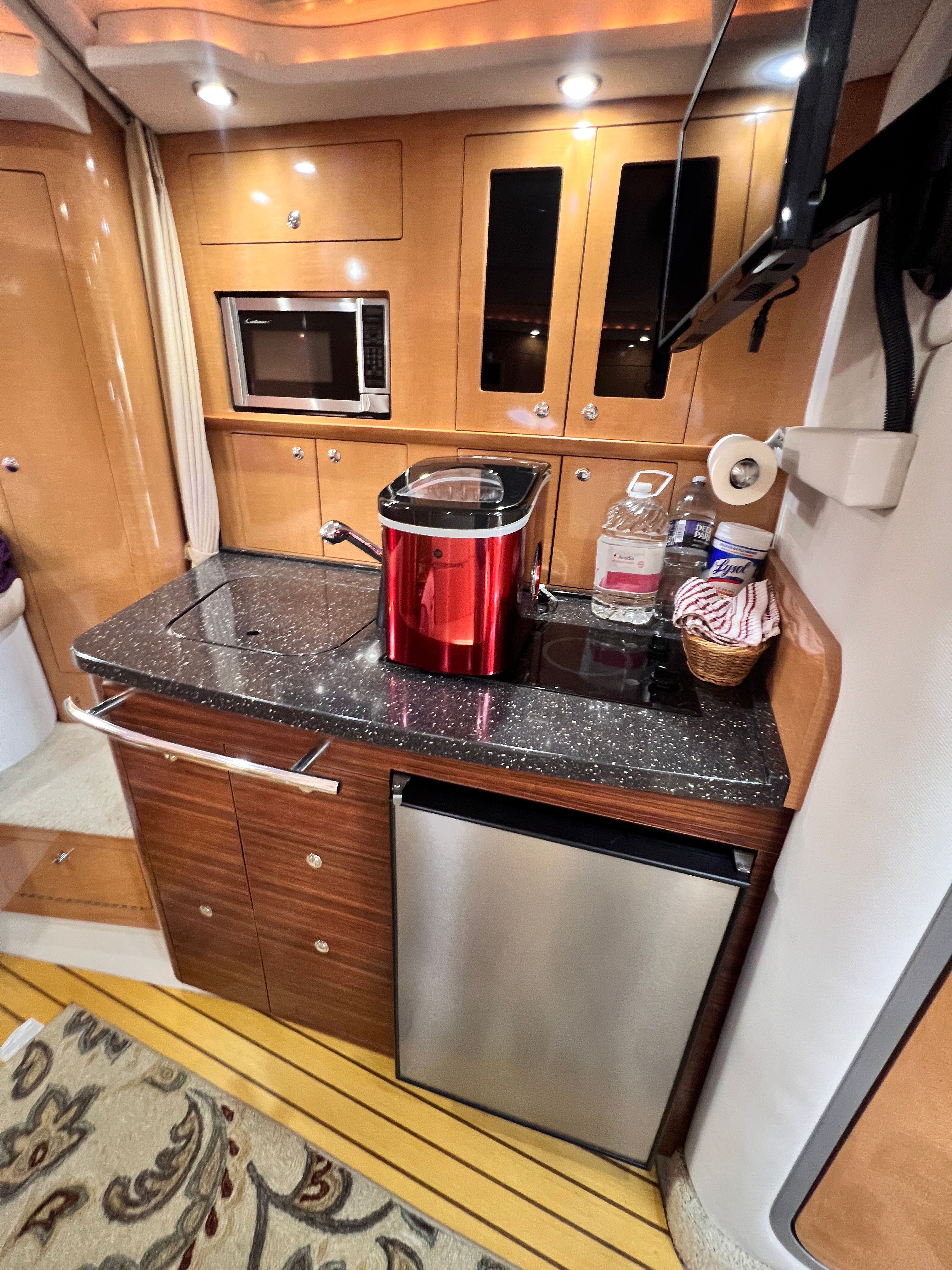 2009 Four Winns V338 yacht interior kitchen with microwave, fridge, and countertop appliances.
