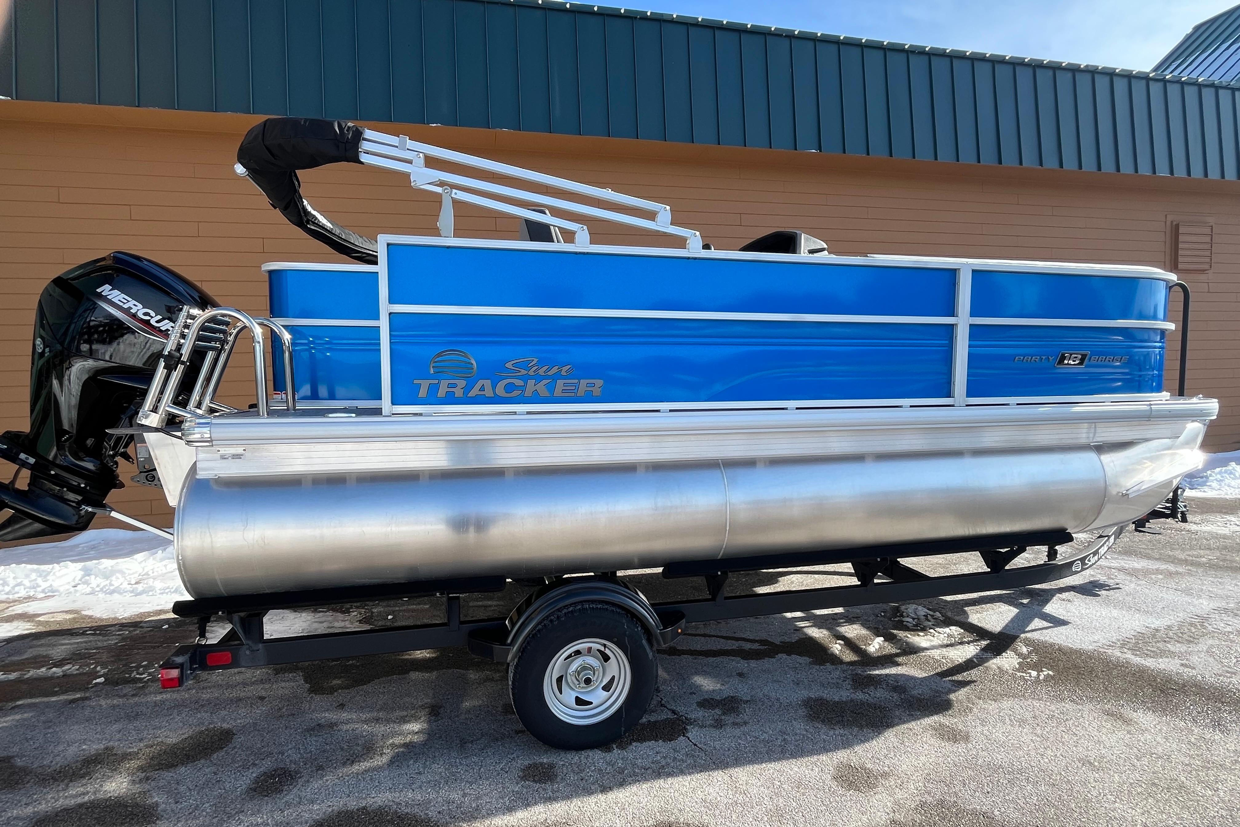2026 Sun Tracker Party Barge 18 DLX pontoon boat on trailer, side view.