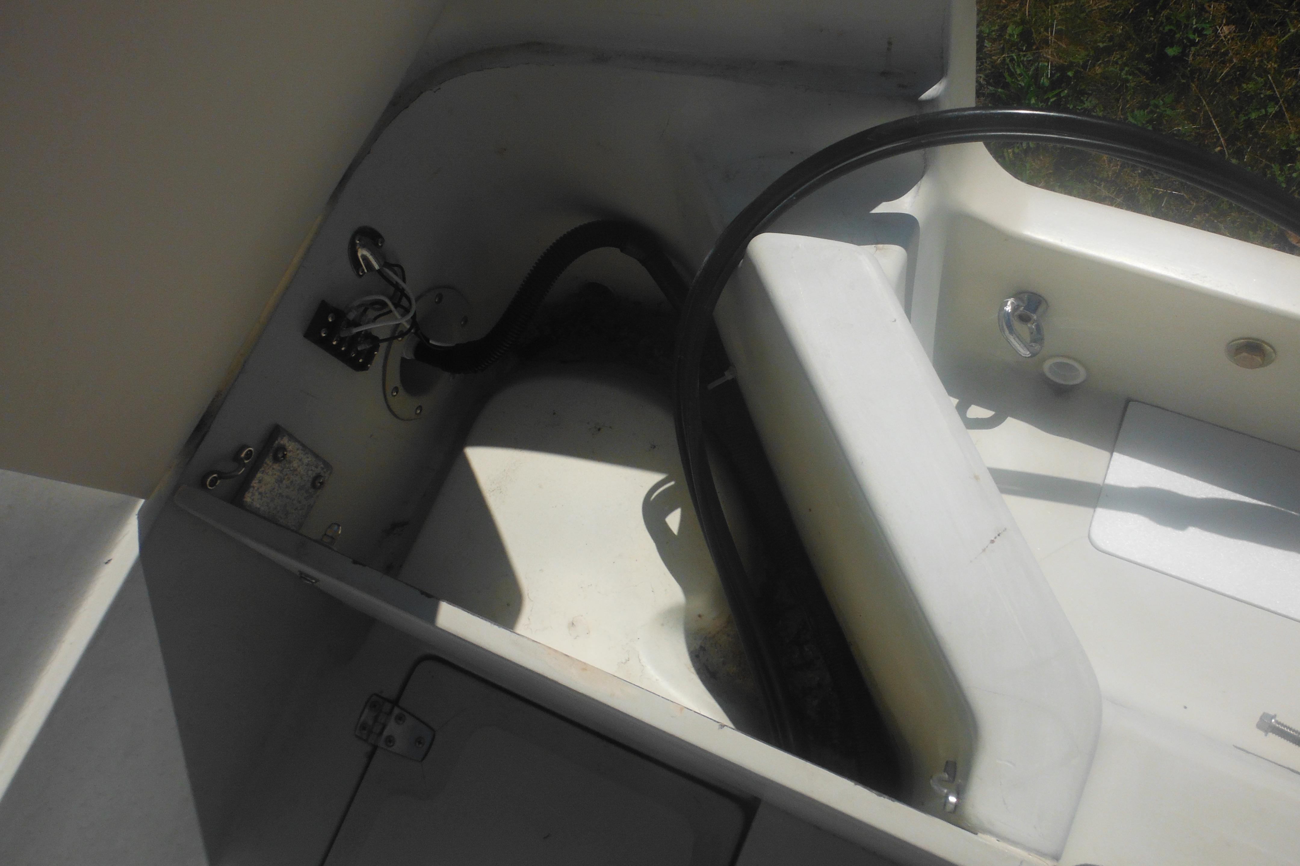 Interior view of a 1991 Boston Whaler 16 SL boat, showcasing steering and seating area.
