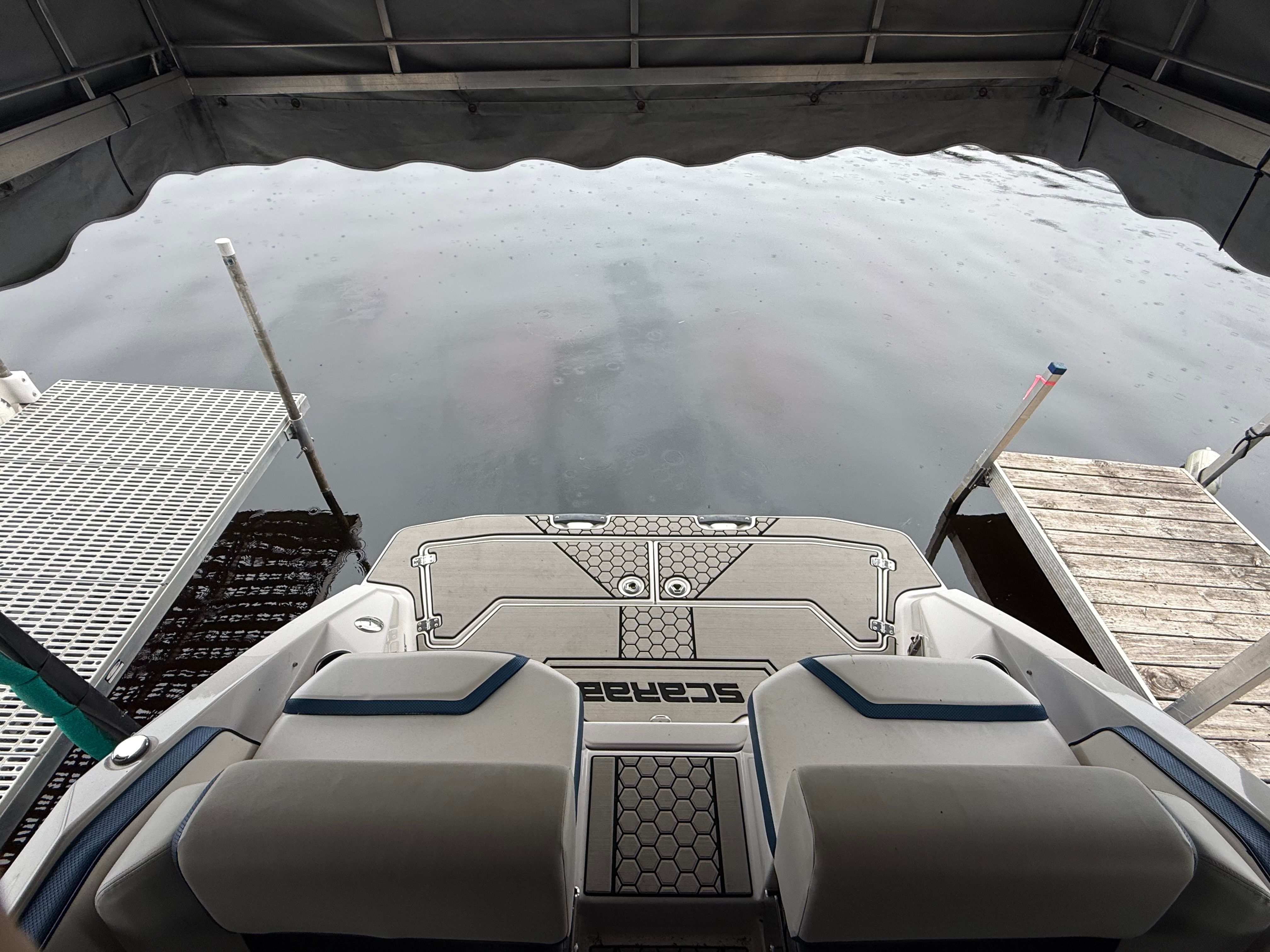 The image shows the stern of a 2018 Scarab 255 HOI boat docked at a pier.