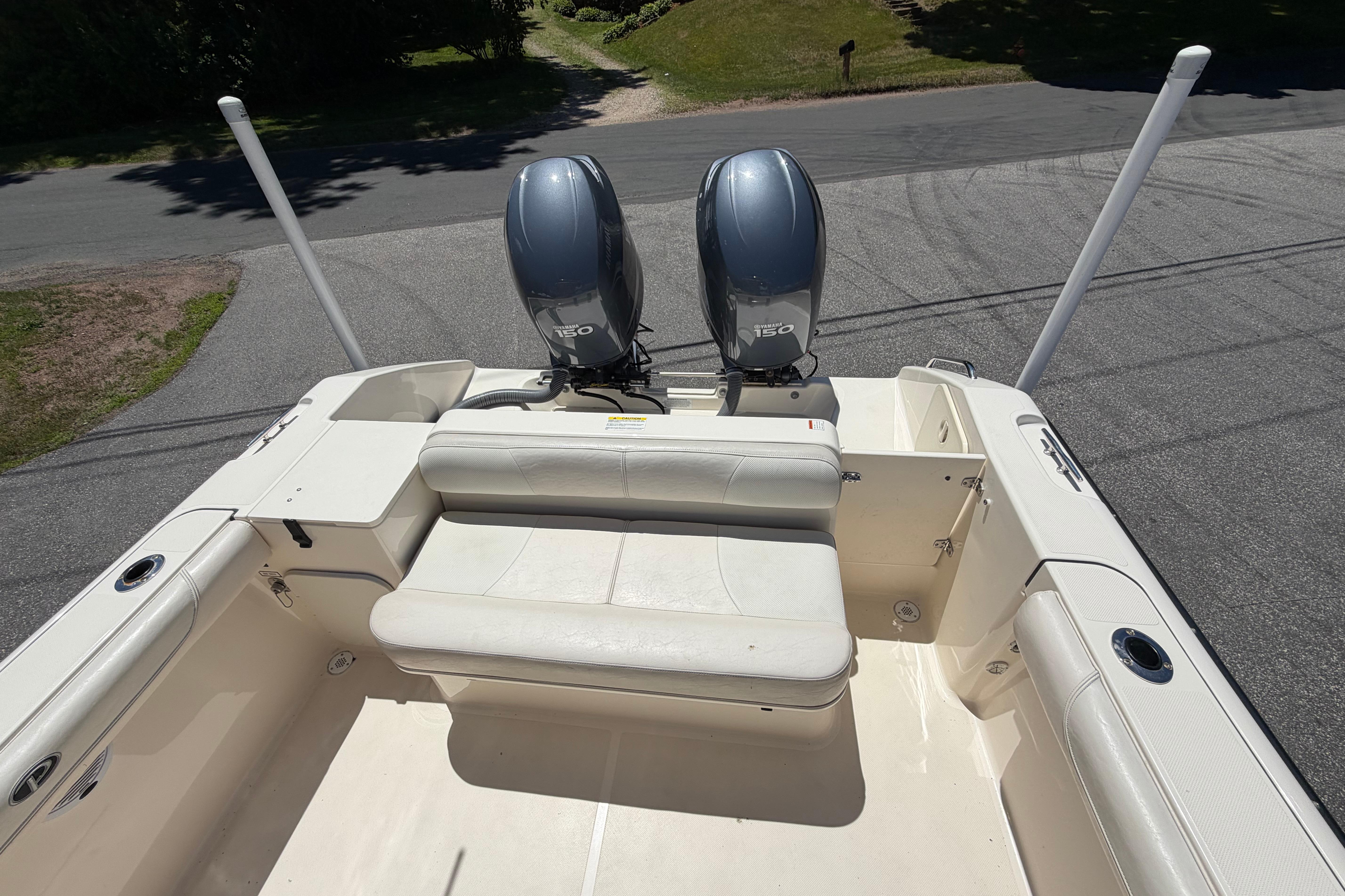 2010 Pursuit OS 255 Offshore boat with dual outboard motors and seating area.
