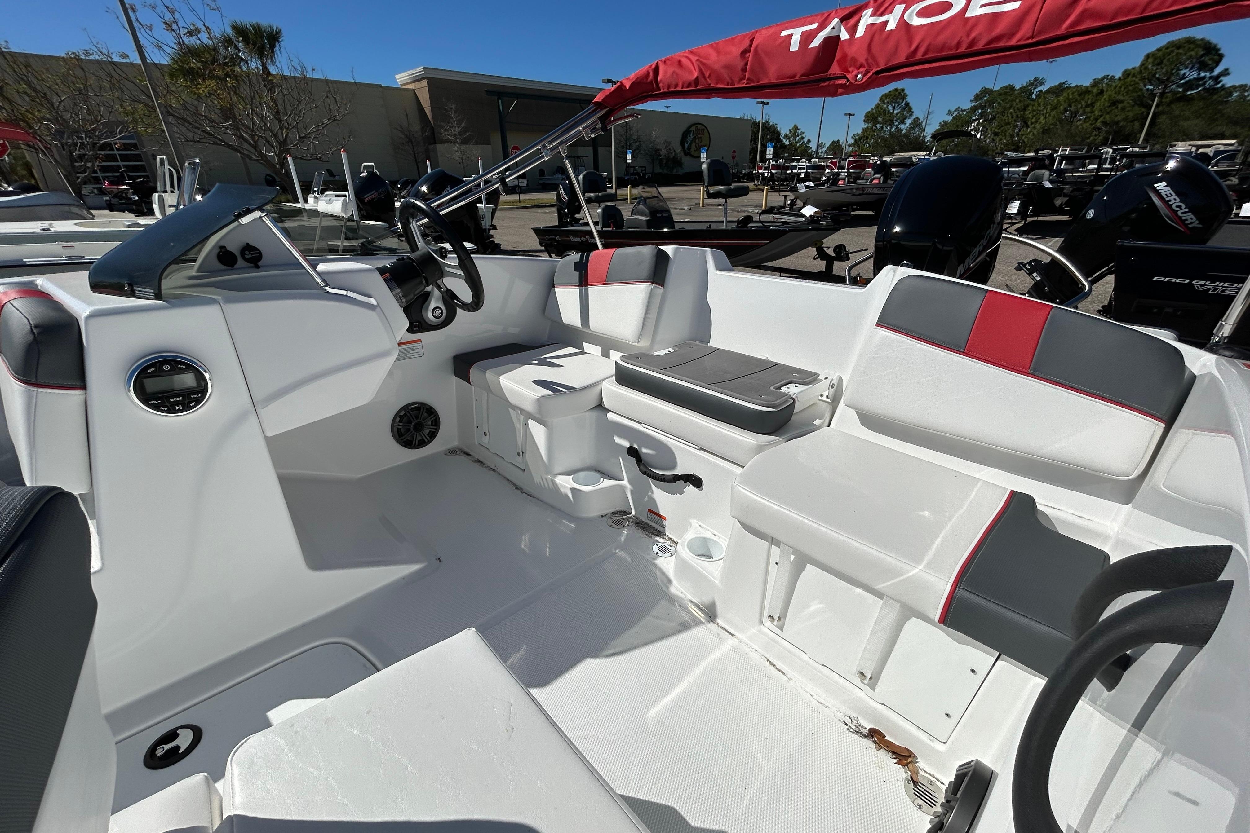 2026 Tahoe T16 boat interior with seating, steering wheel, and red canopy.