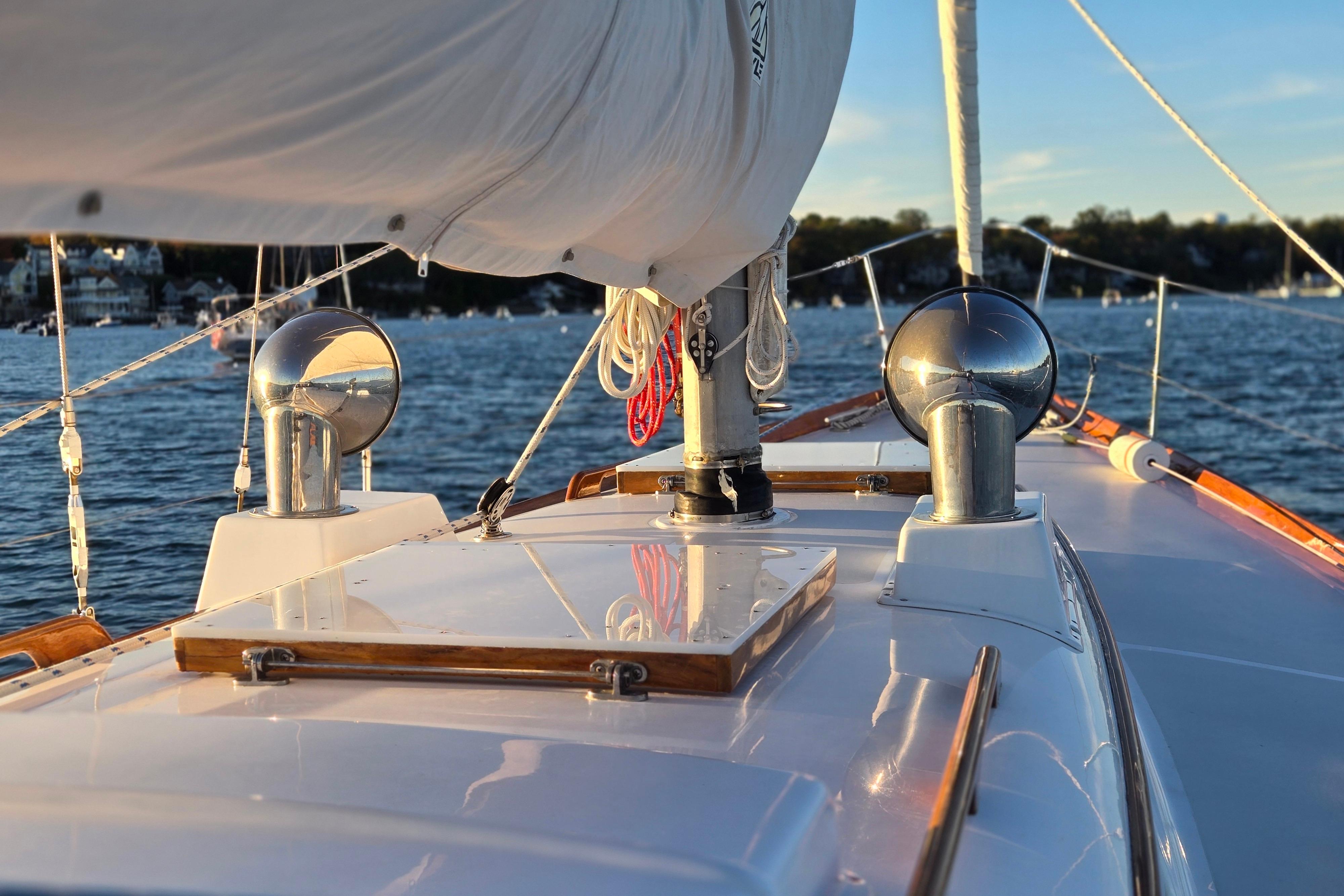 Hinckley Bermuda 40 sailboat deck, 1970 model, sailing on a sunny day with scenic background.