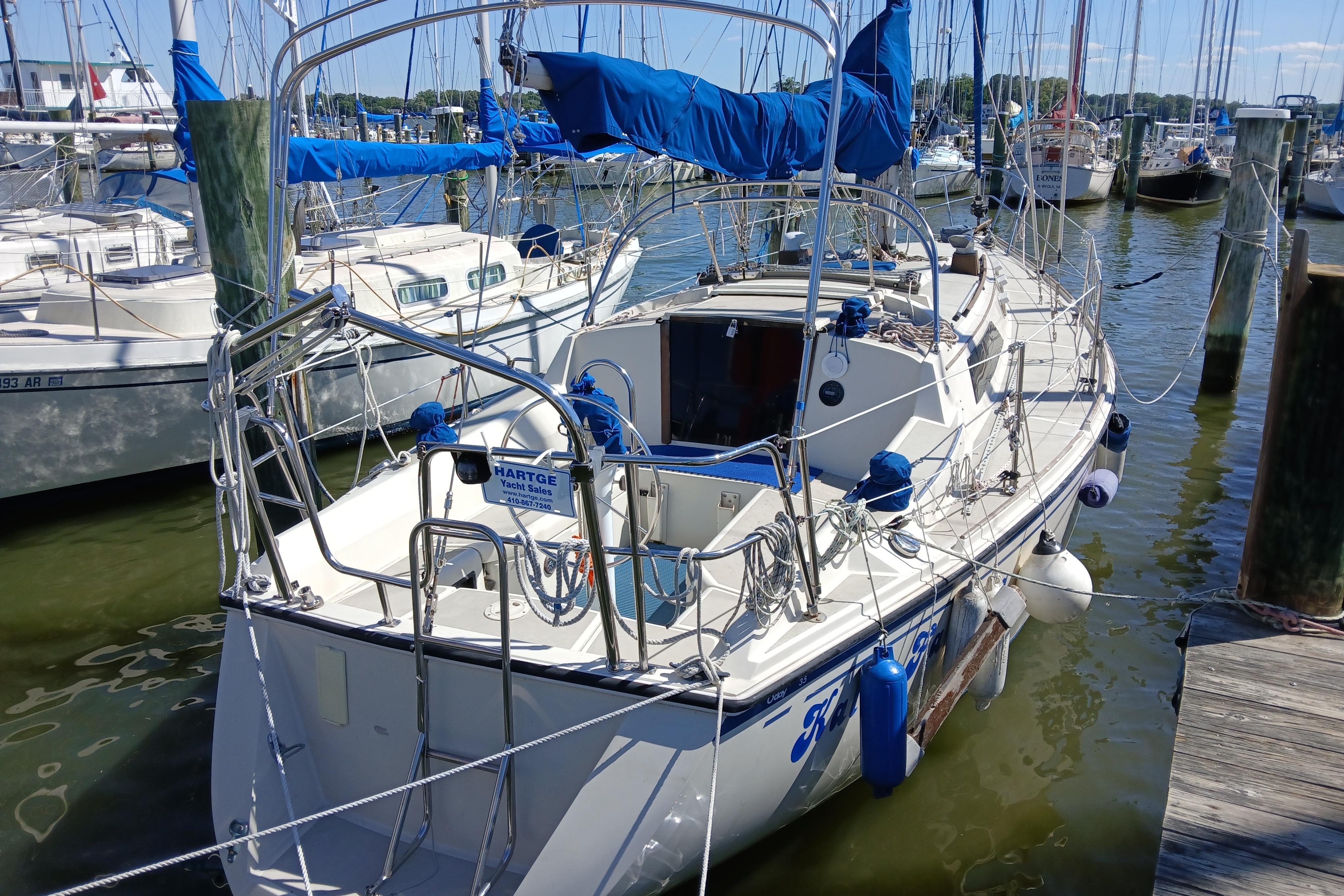 1986 O'Day 35 sailboat docked at a marina, featuring blue sail covers.