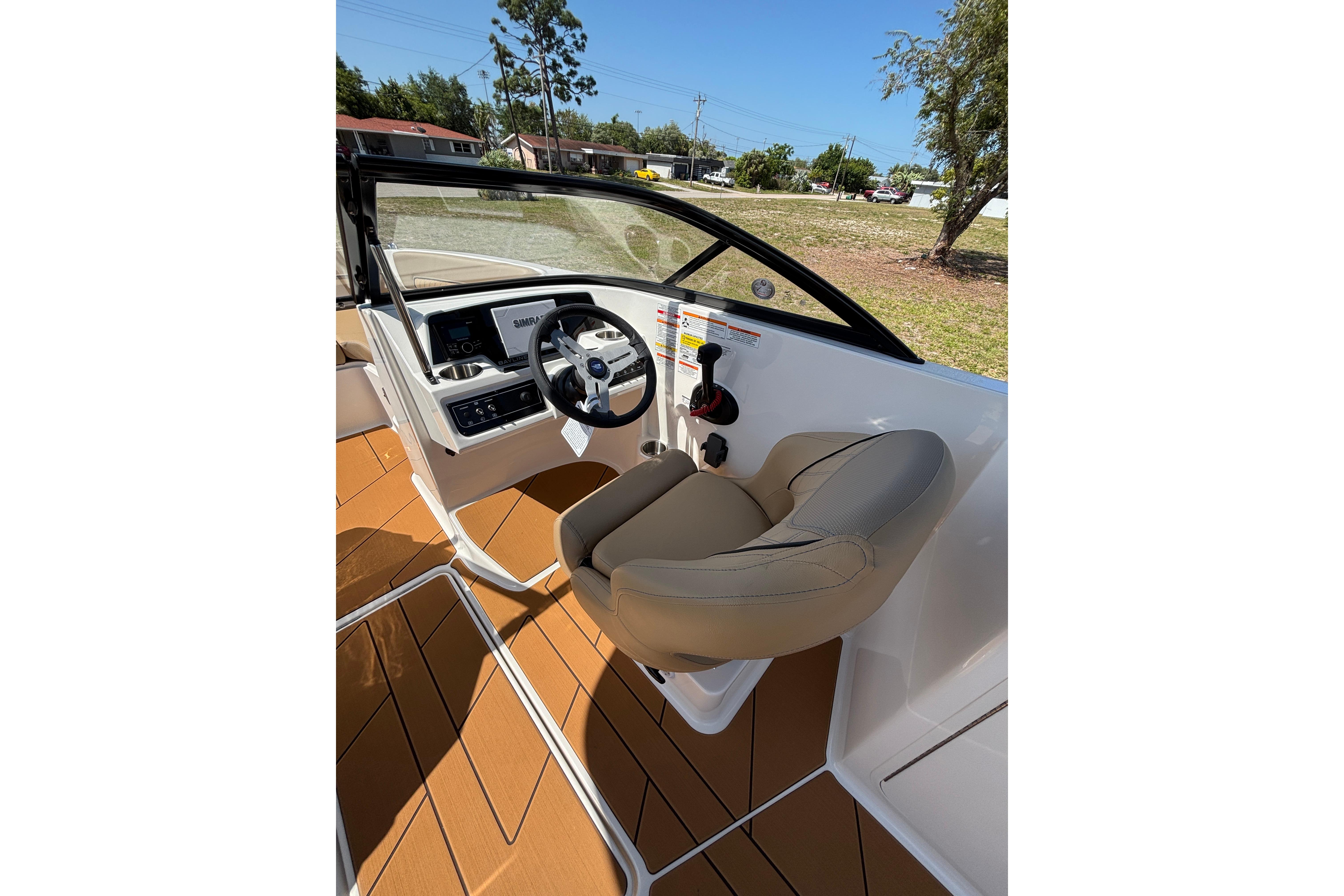 2026 Bayliner D22 boat cockpit with steering wheel and comfortable seating.