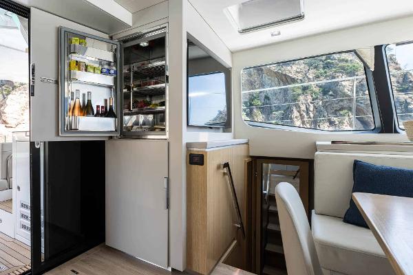 Luxury interior of 2025 Privilege Signature 580 yacht with open fridge and scenic view.