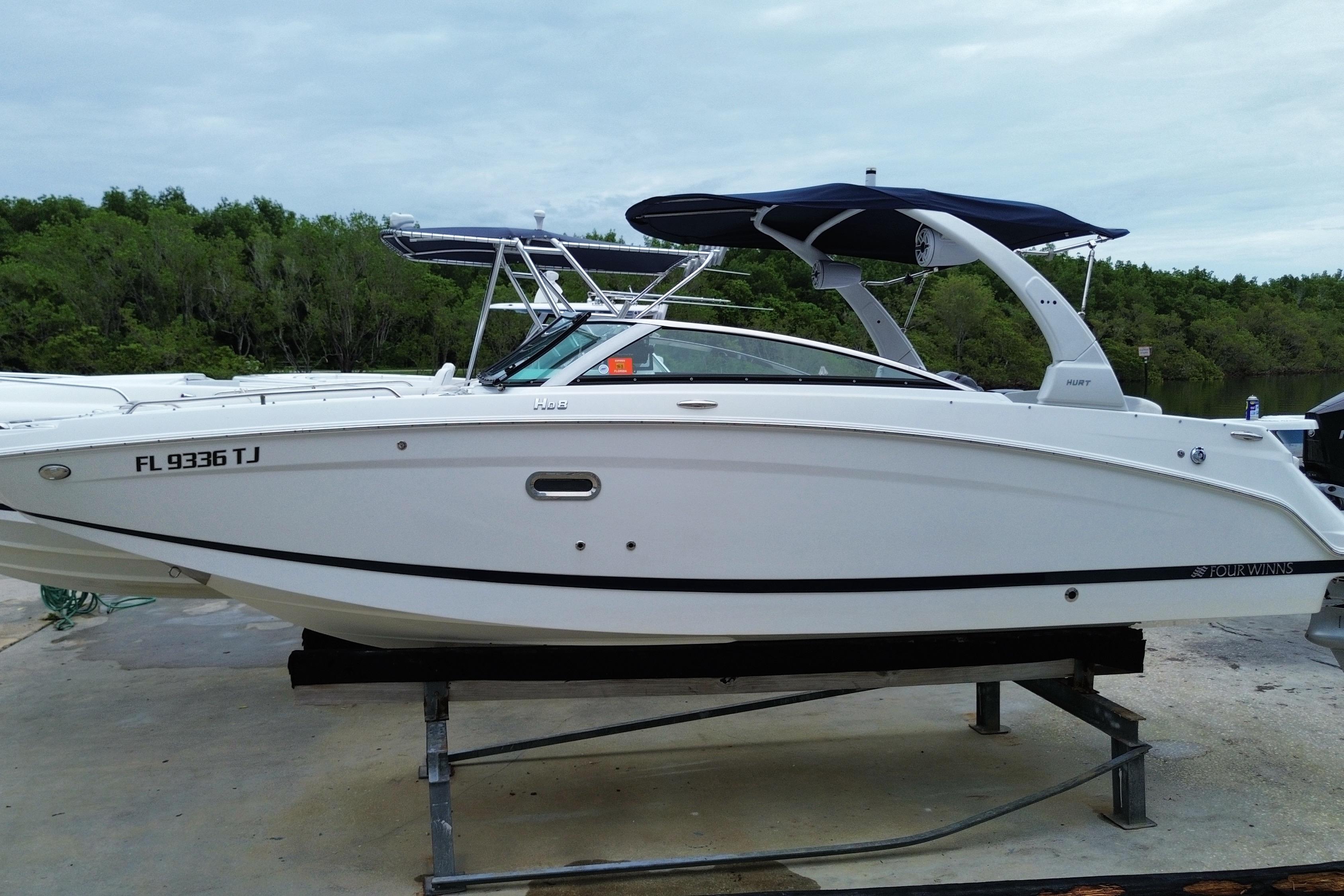 2022 Four Winns HD8 OB boat on a stand, featuring sleek design and canopy.