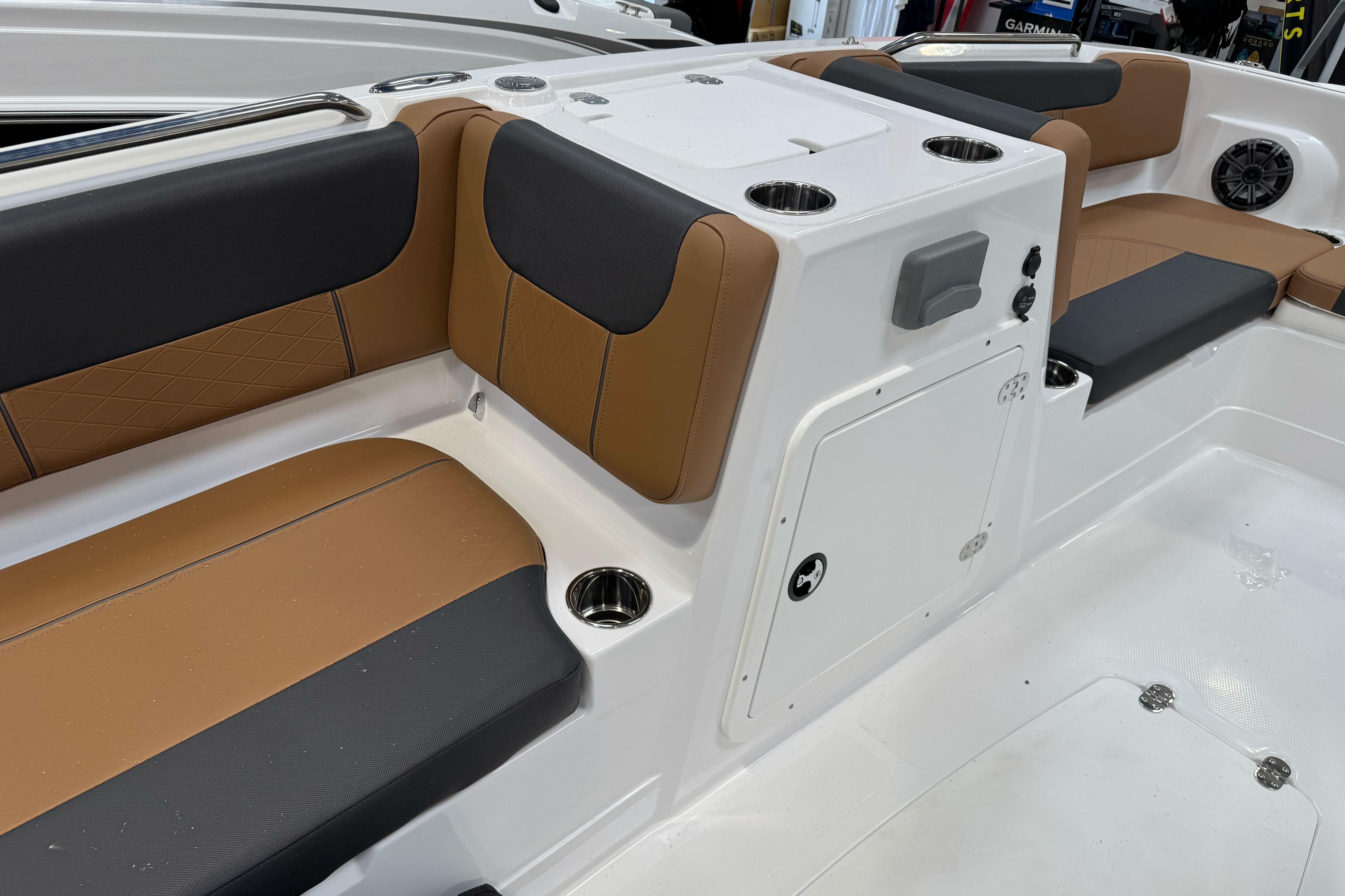 2026 Tahoe 2150 boat interior with tan and black seating, cup holders, and storage compartment.