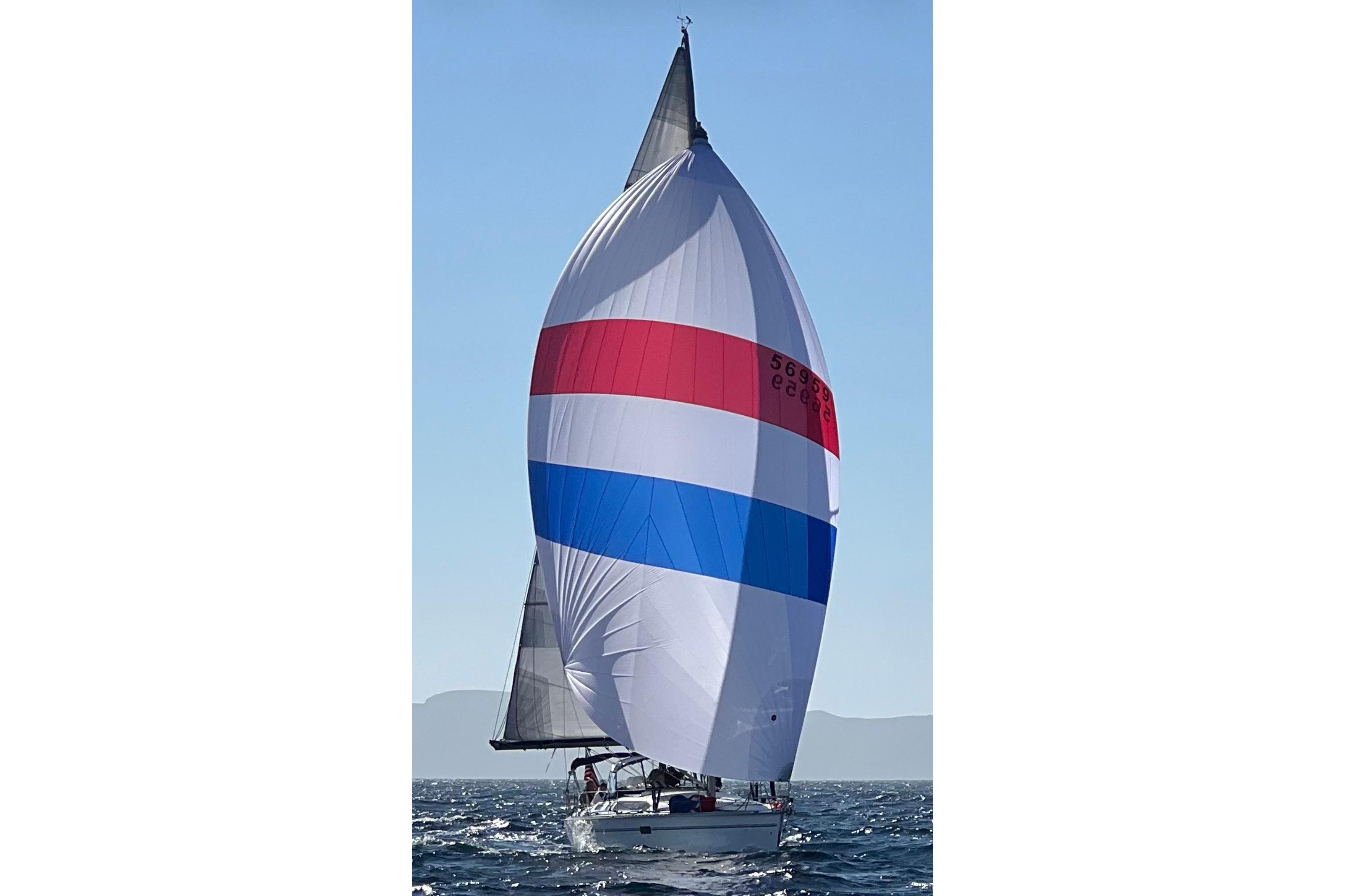 Sailboat Hunter Legend 40.5 (1997) with colorful spinnaker on open water.
