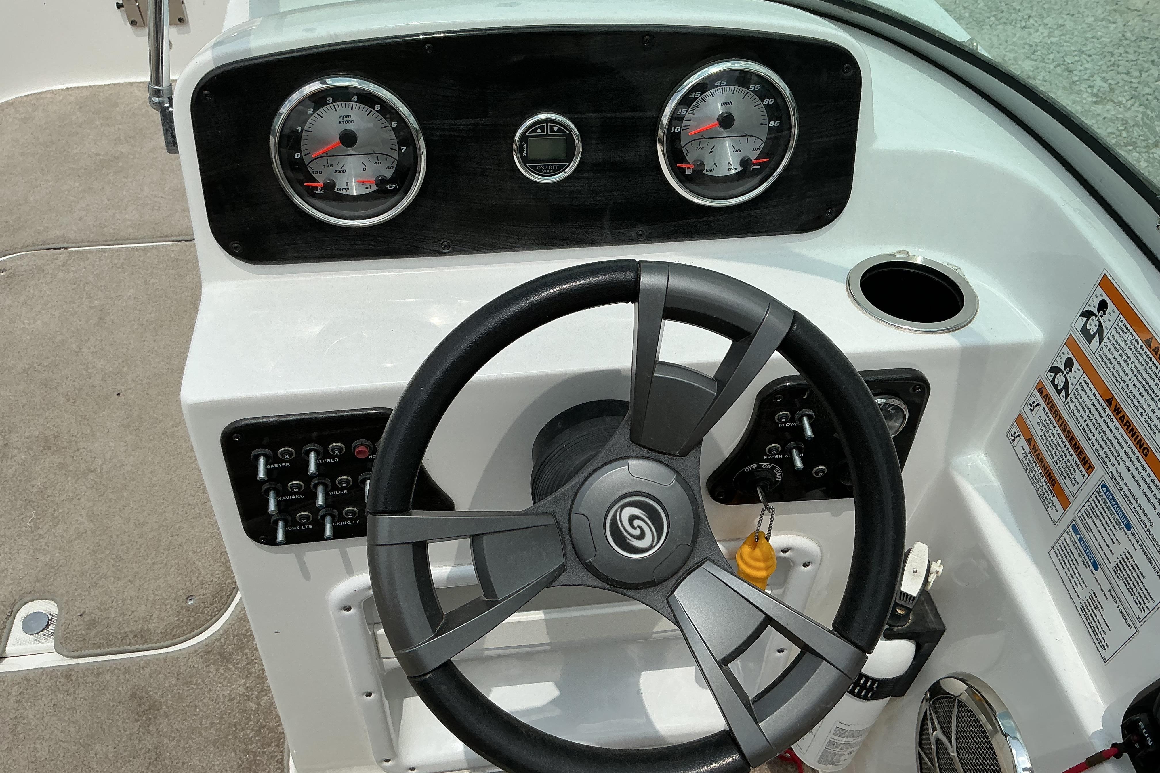Dashboard of a 2015 Hurricane SunDeck 187 IO boat with steering wheel and gauges.