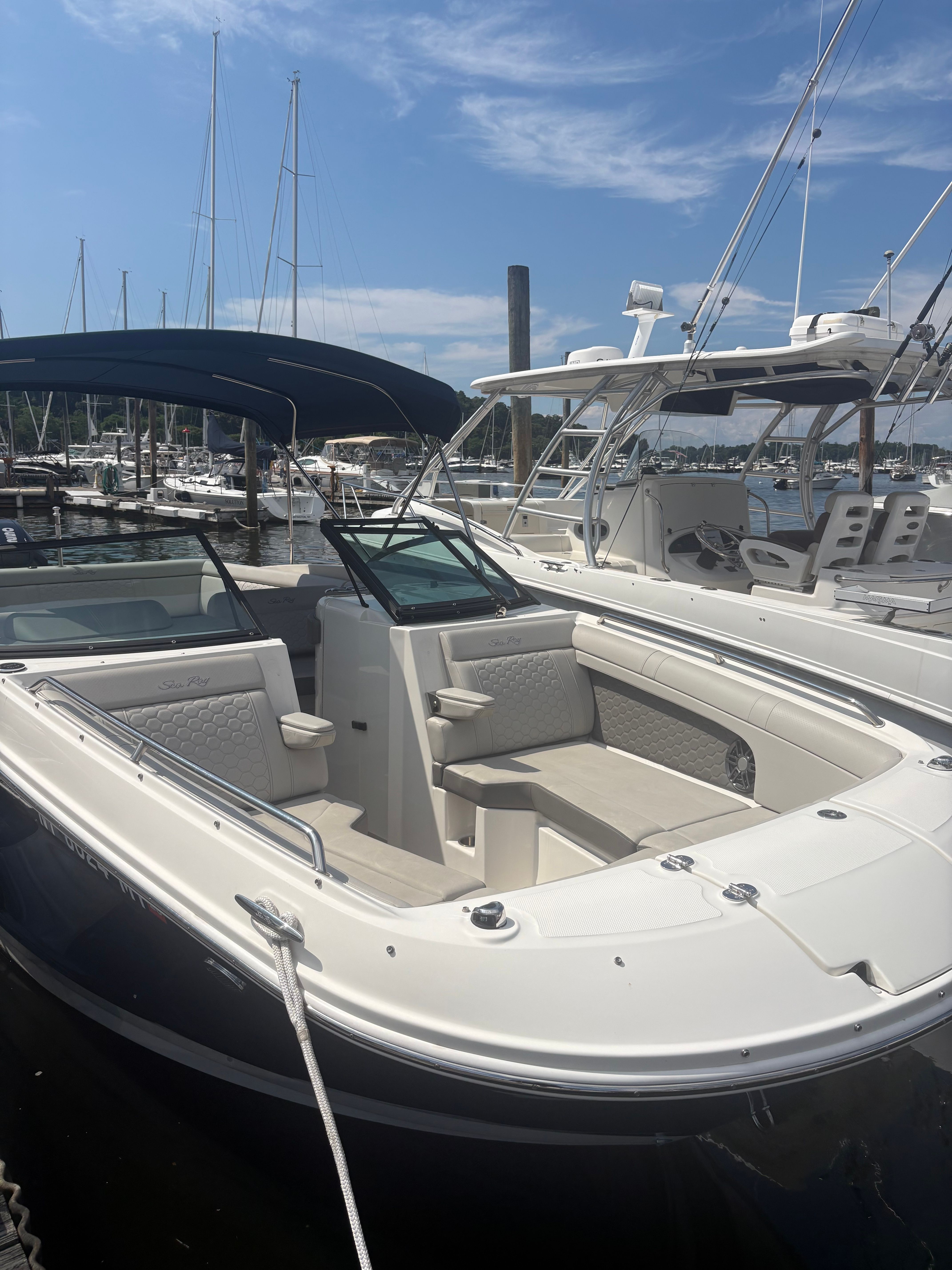 A 2022 Sea Ray SDX 270 Outboard docked at a marina. It features an open deck and seating area.