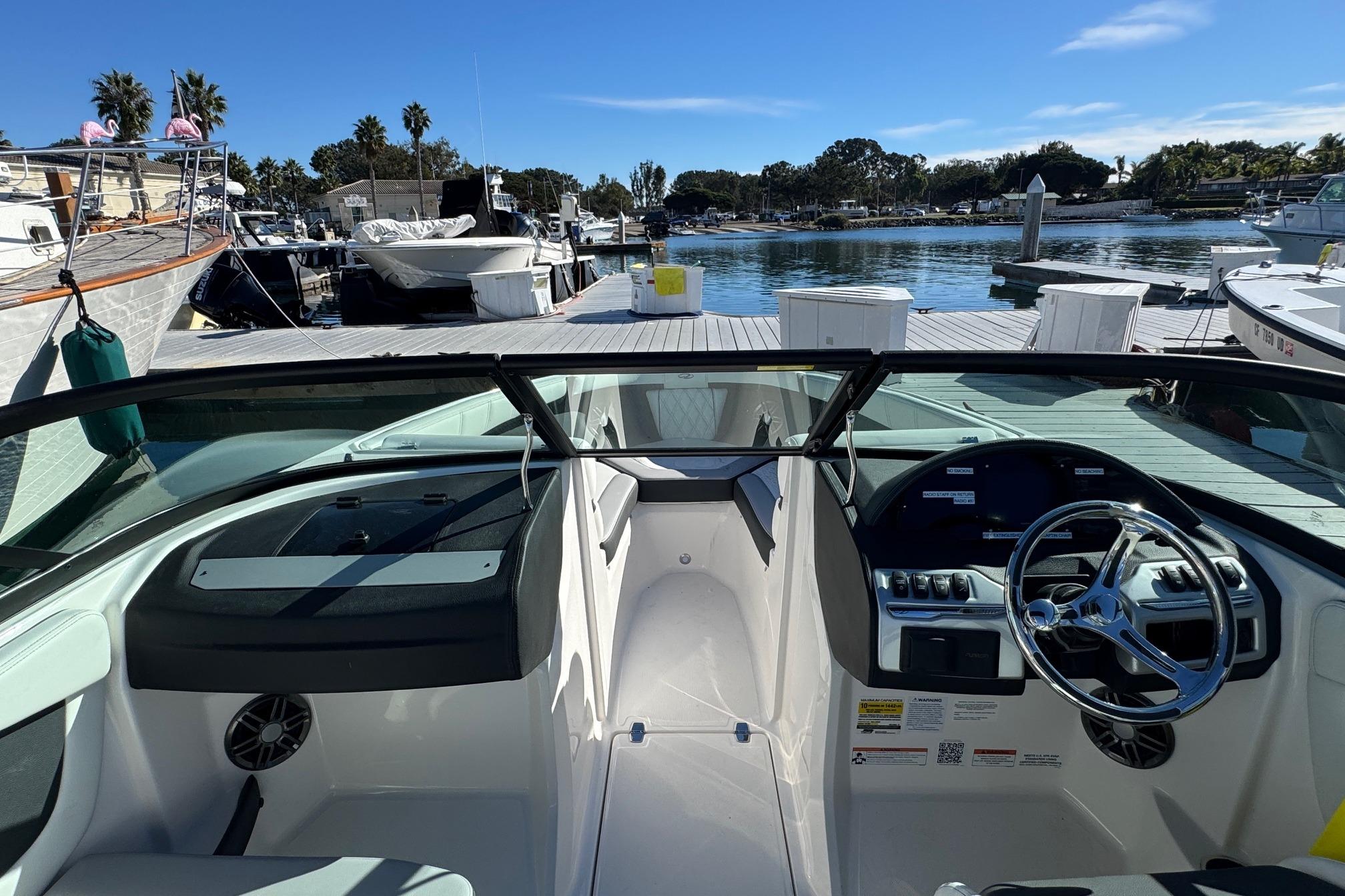2026 Regal 21 OBX boat interior at marina, featuring steering wheel and dashboard.