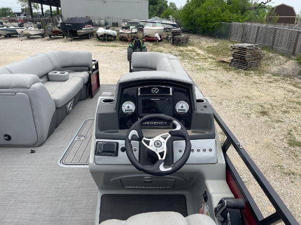 2023 Regency 250DL3 pontoon boat interior with steering console and seating area.