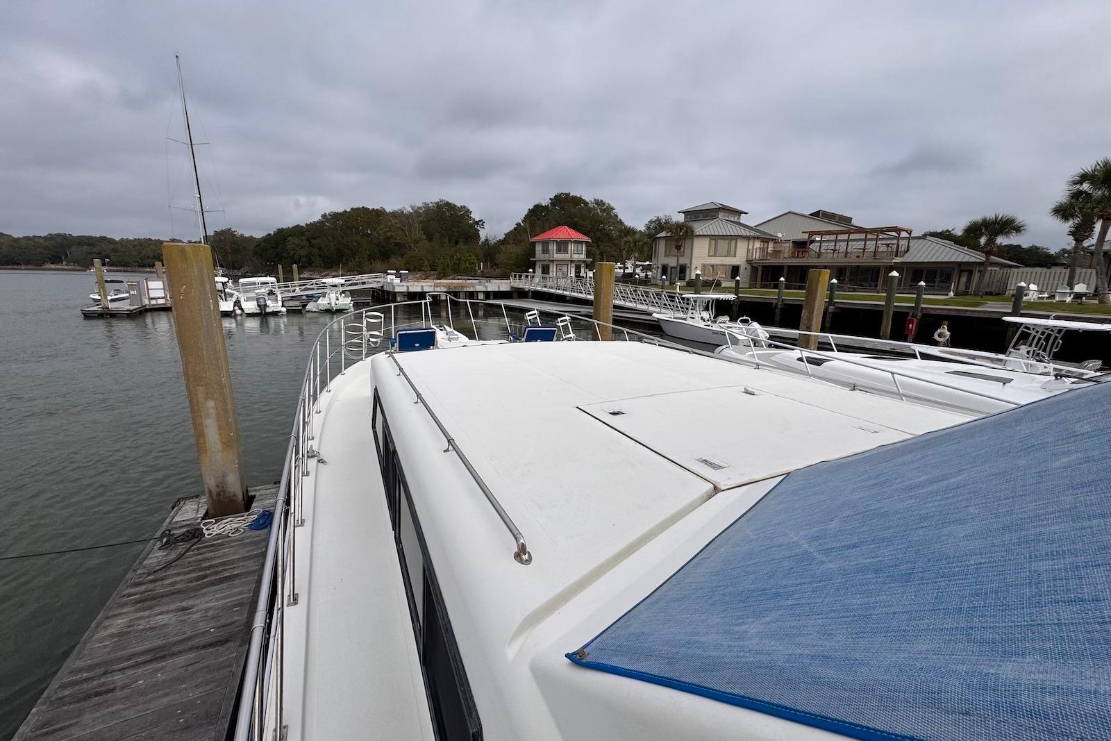 1988 Jefferson 52 Monticello yacht docked at a marina with waterfront homes.