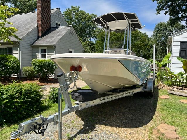 A 2022 Carolina Skiff 21 Ultra Elite on a trailer in a garden setting.