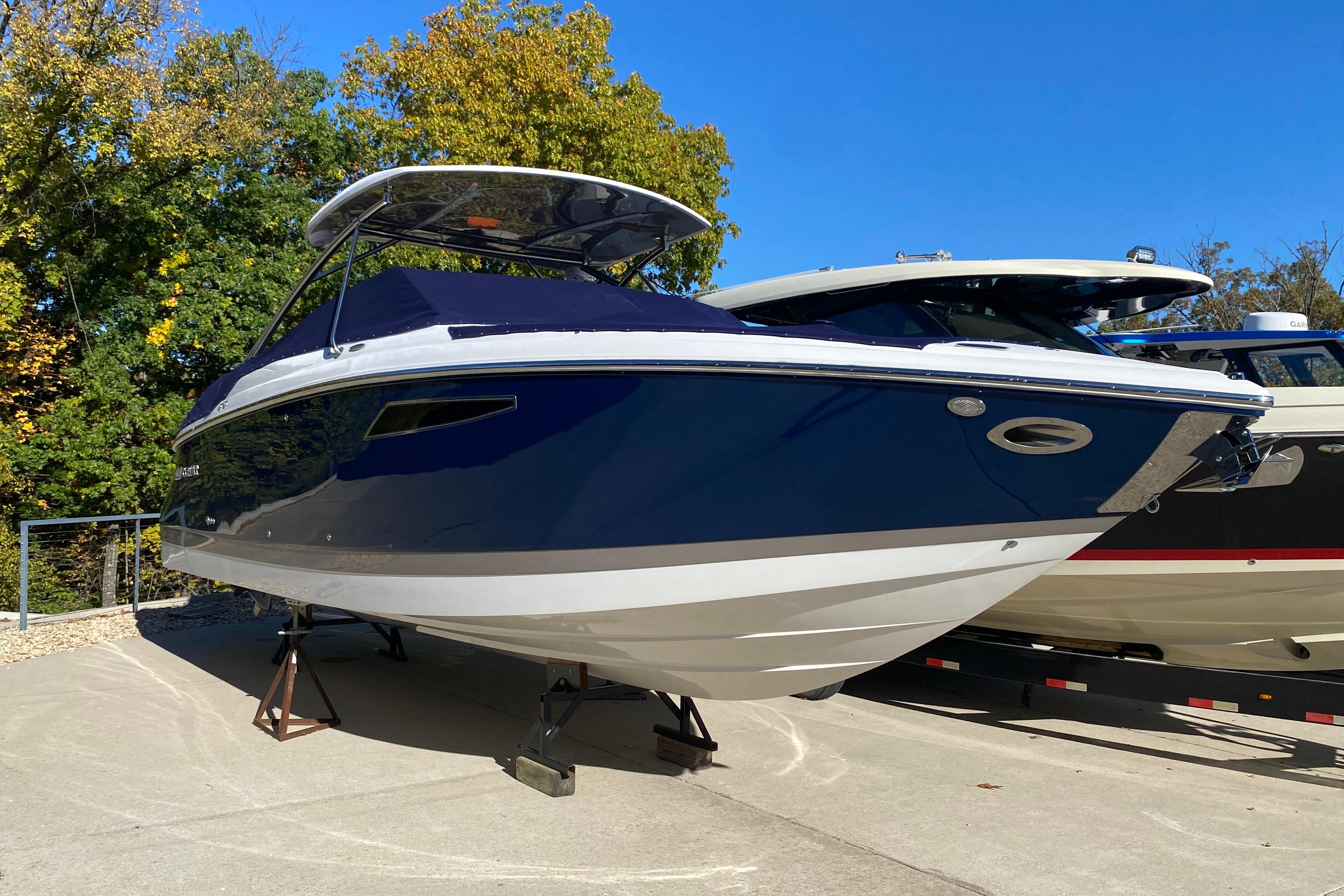 2022 Cobalt R35 boat on display, blue and white design, sunny day, surrounded by trees.