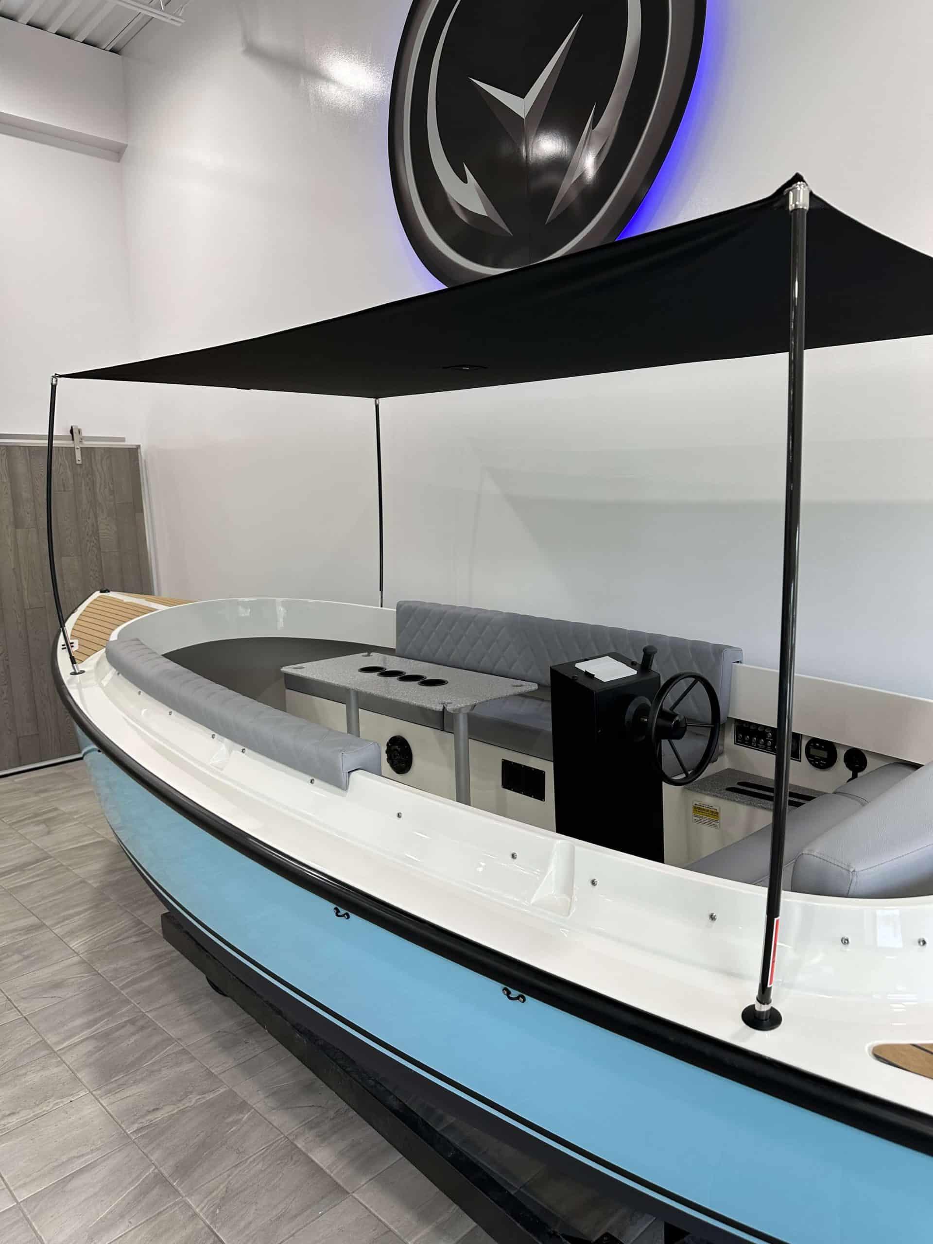 2023 Vision Marine Technologies Fantail 217 boat with canopy, displayed indoors.