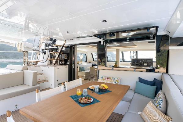 Luxurious 2025 Privilege Signature 580 yacht interior with dining area and helm station.