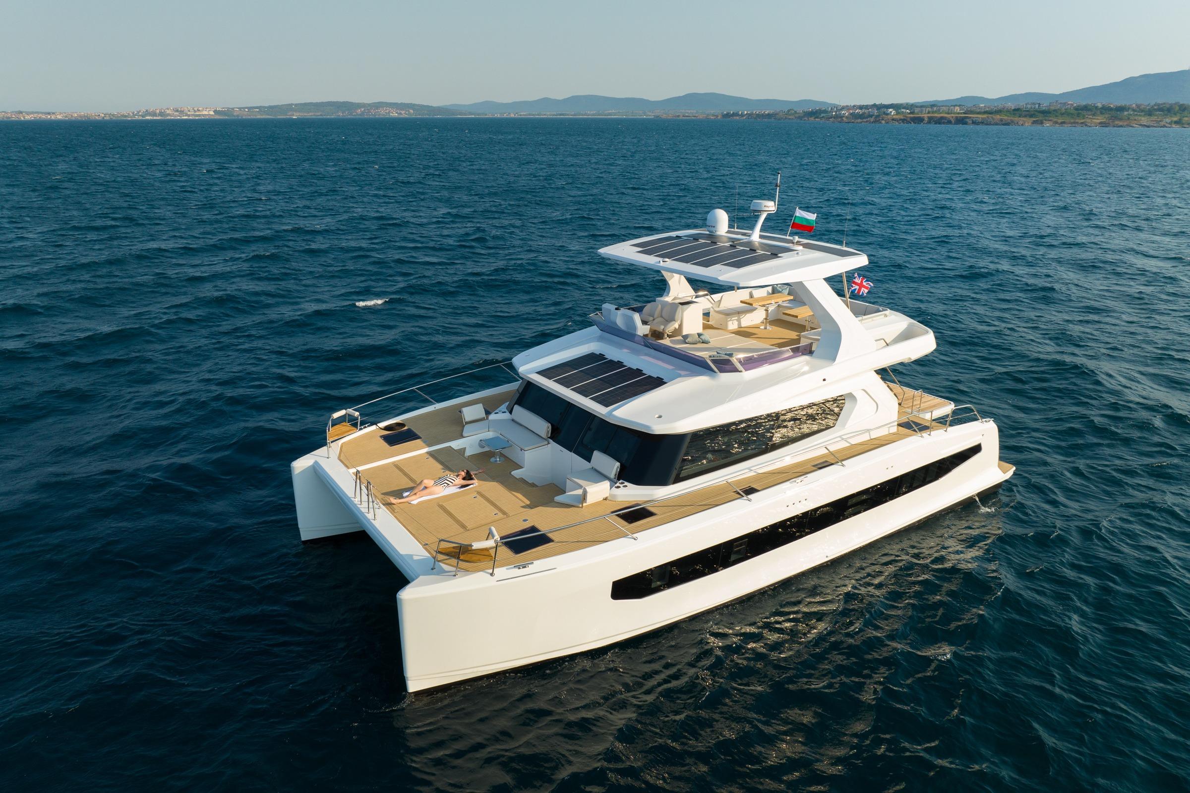 Luxurious 2025 Omaya 50 Power Catamaran cruising on open sea, showcasing sleek design and spacious deck.