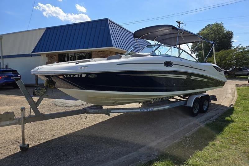 2011 Sea Ray 300 Sundeck boat on trailer, parked outdoors.