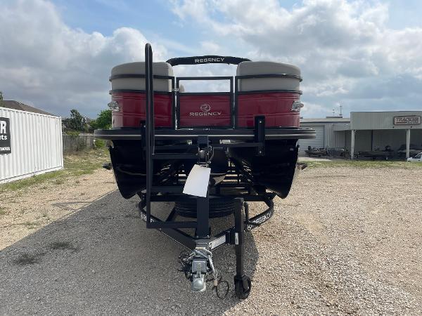 2023 Regency 250DL3 pontoon boat on trailer, parked outdoors under cloudy sky.