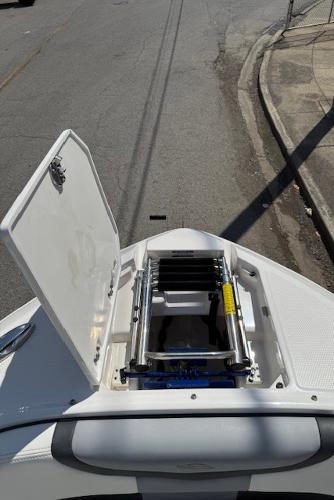 2023 Chaparral 267 SSX boat with open bow storage compartment and ladder.