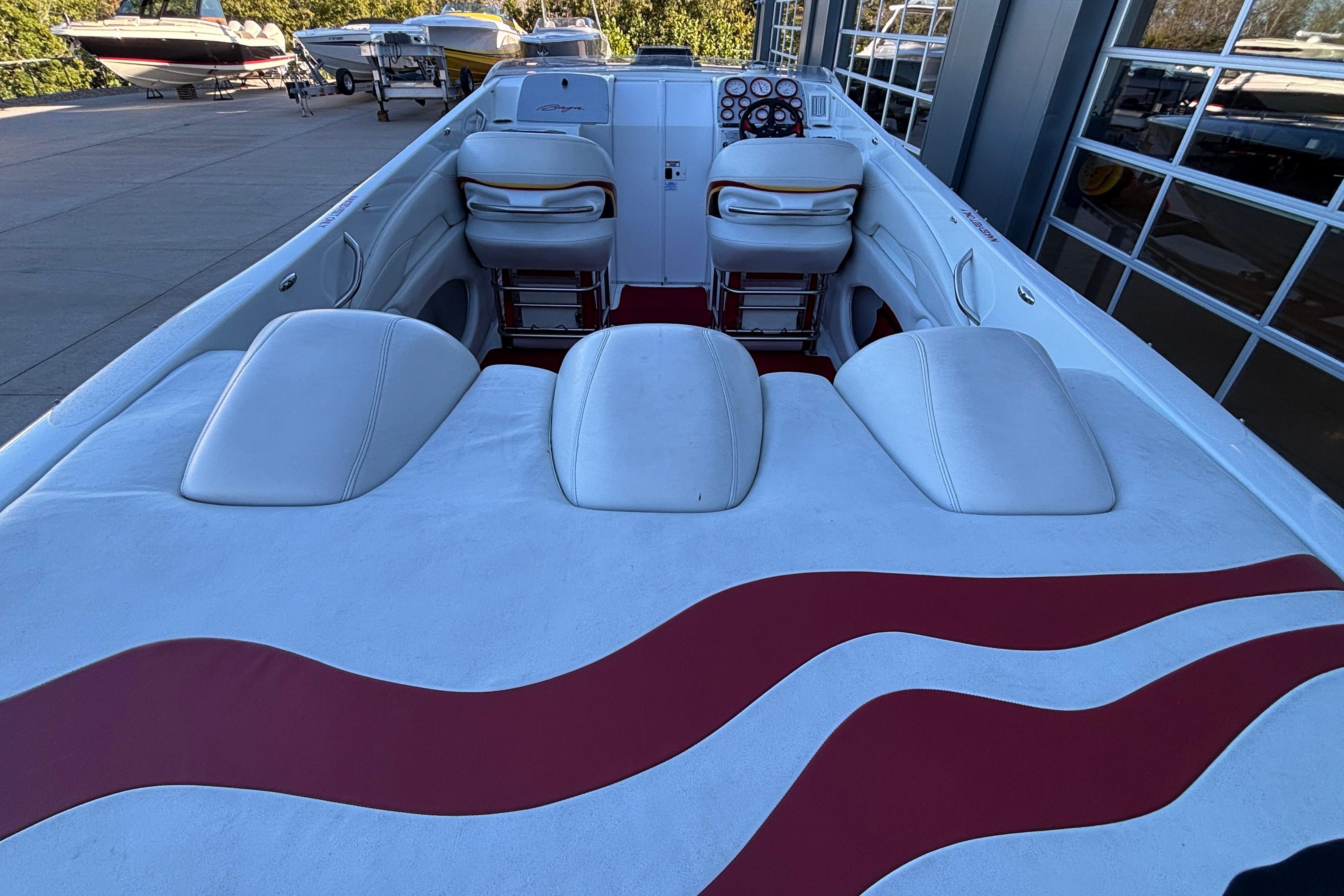 2001 Baja 33 Outlaw boat interior with white and red seating, docked outdoors.