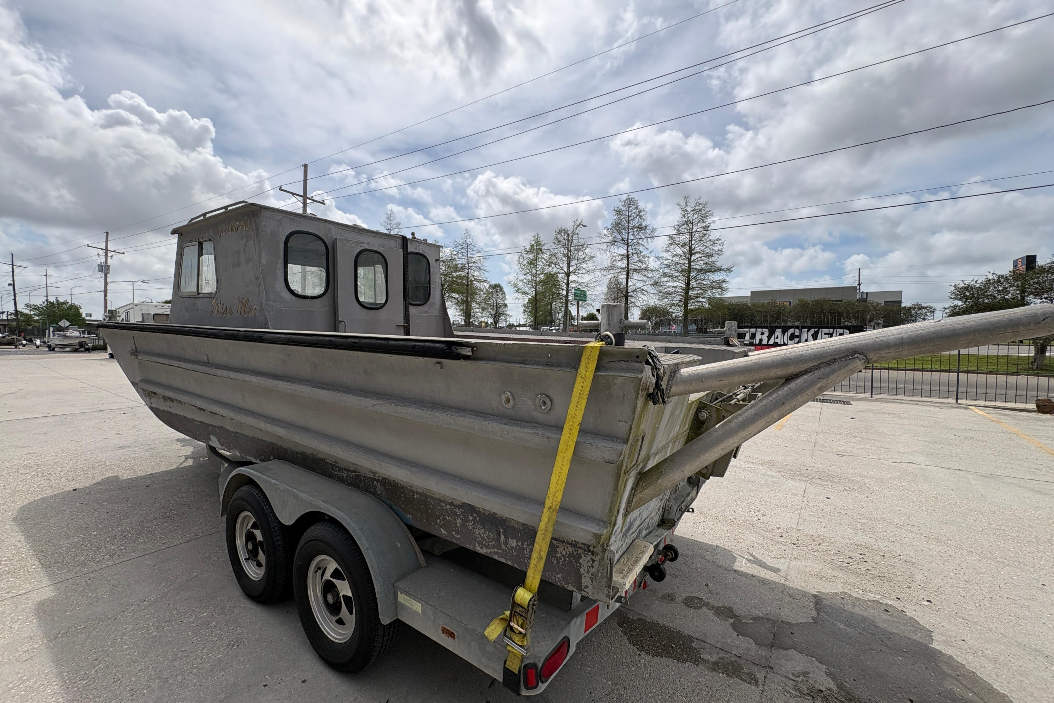 1972 Custom 23' work/push boat on trailer, parked outdoors under cloudy sky.
