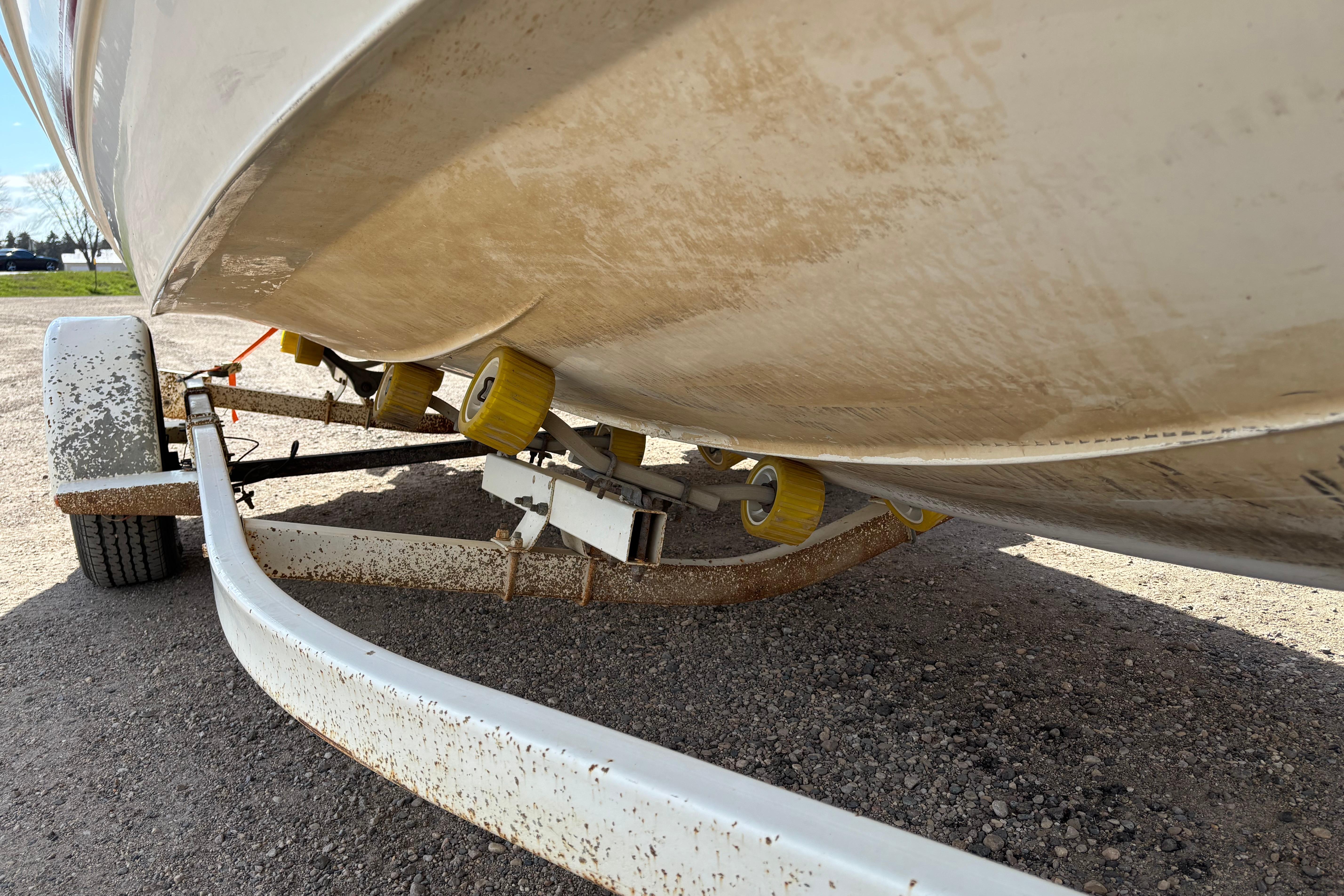 1993 Larson SEi 200 Cuddy I/O boat on a trailer, showing hull and rollers.