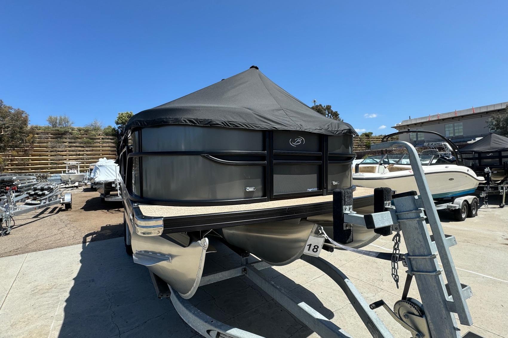 2023 Barletta Cabrio 22UC pontoon boat on trailer, covered and parked outdoors.