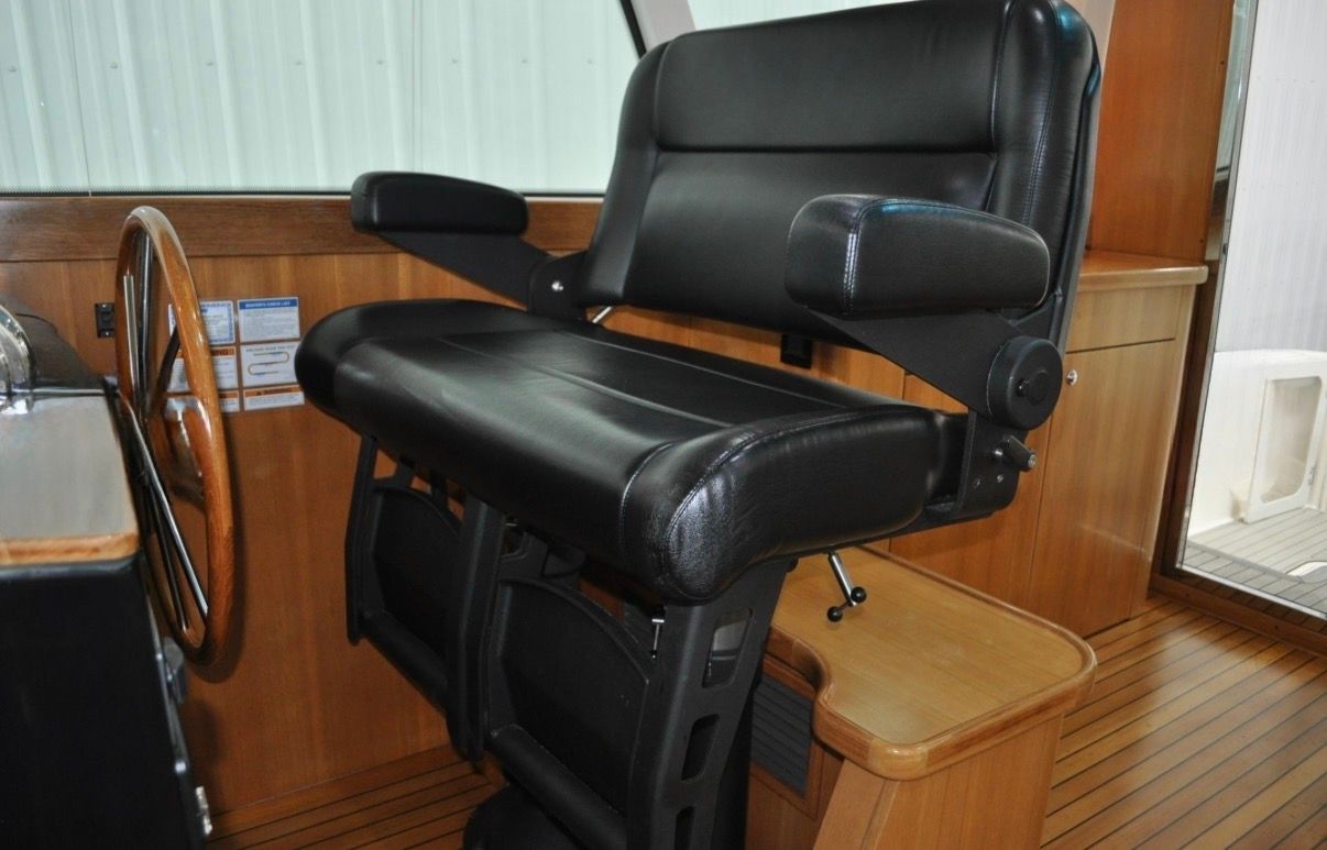 The interior of a 2005 Tiara Yachts 5200 Sovran features a black leather seat with armrests.