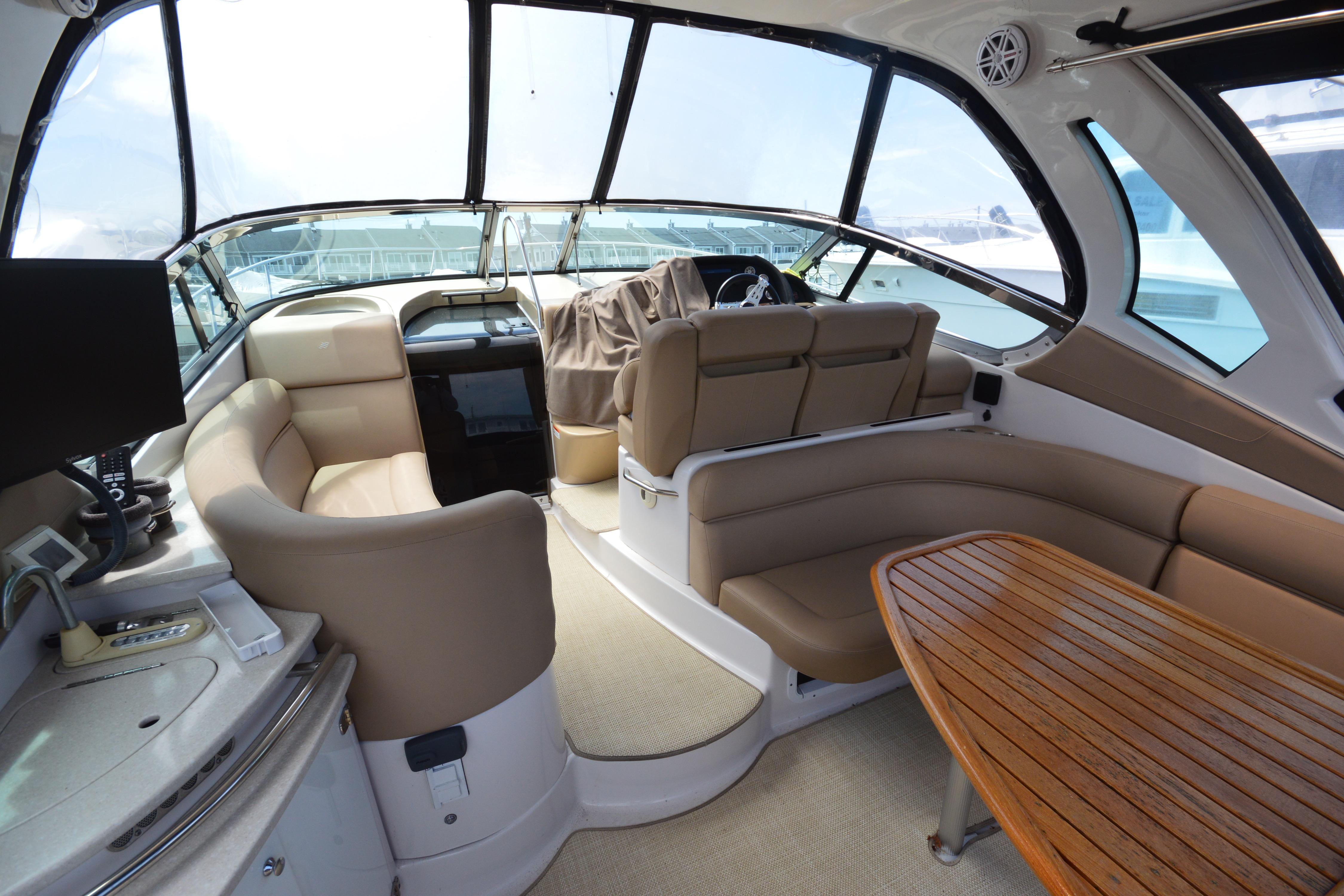 Interior of 2013 Four Winns V375 yacht with beige seating and wooden table.