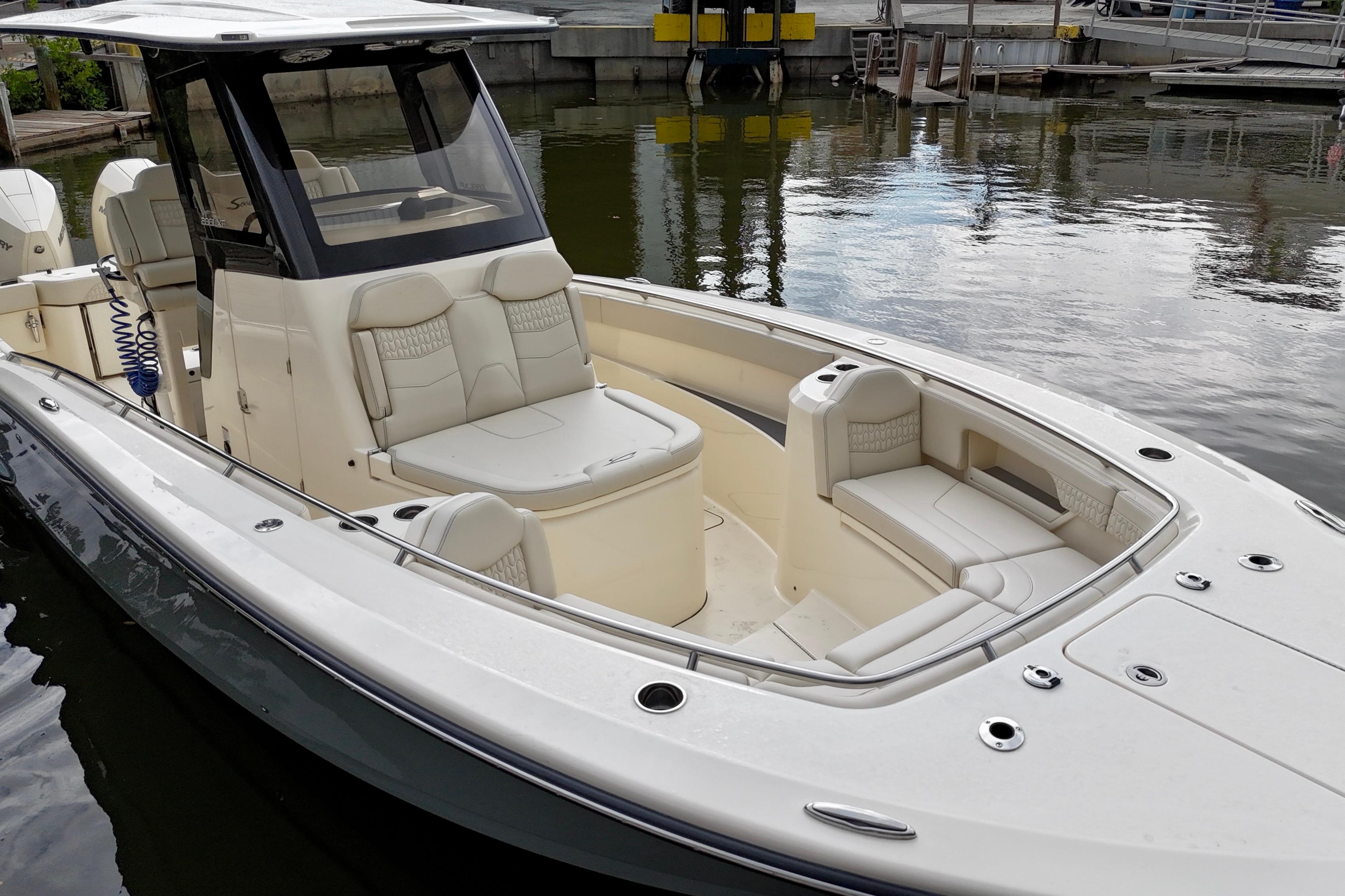 2026 Scout 288 LXF boat with luxurious seating, docked in a marina.