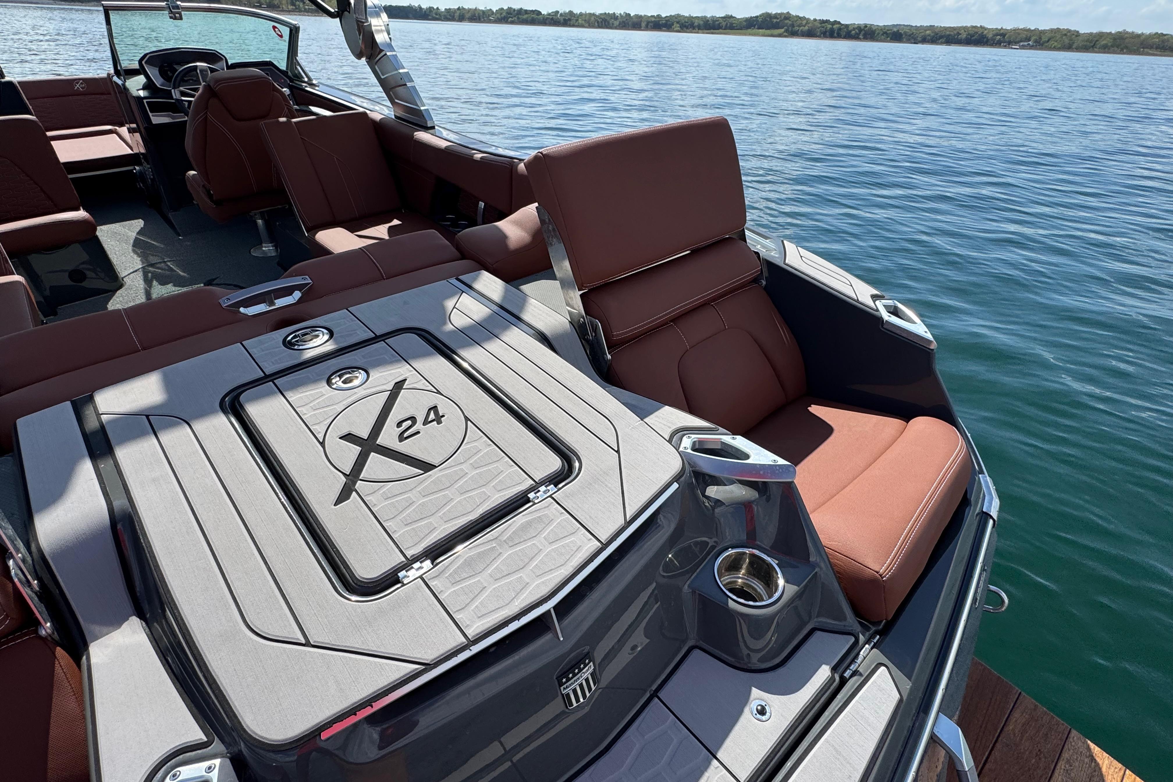 2021 MasterCraft X24 boat interior with brown seating on a lake.