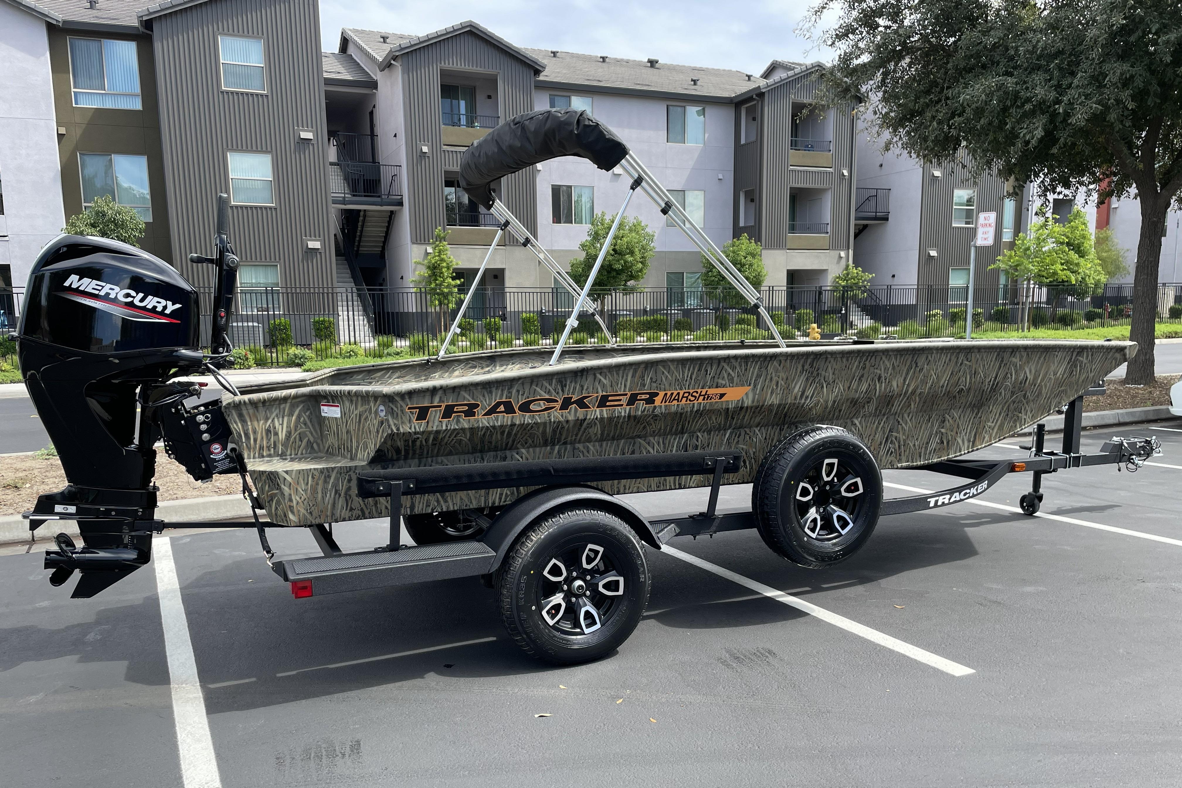 2026 Tracker Grizzly 1756 T Marsh boat with Mercury engine in parking lot.