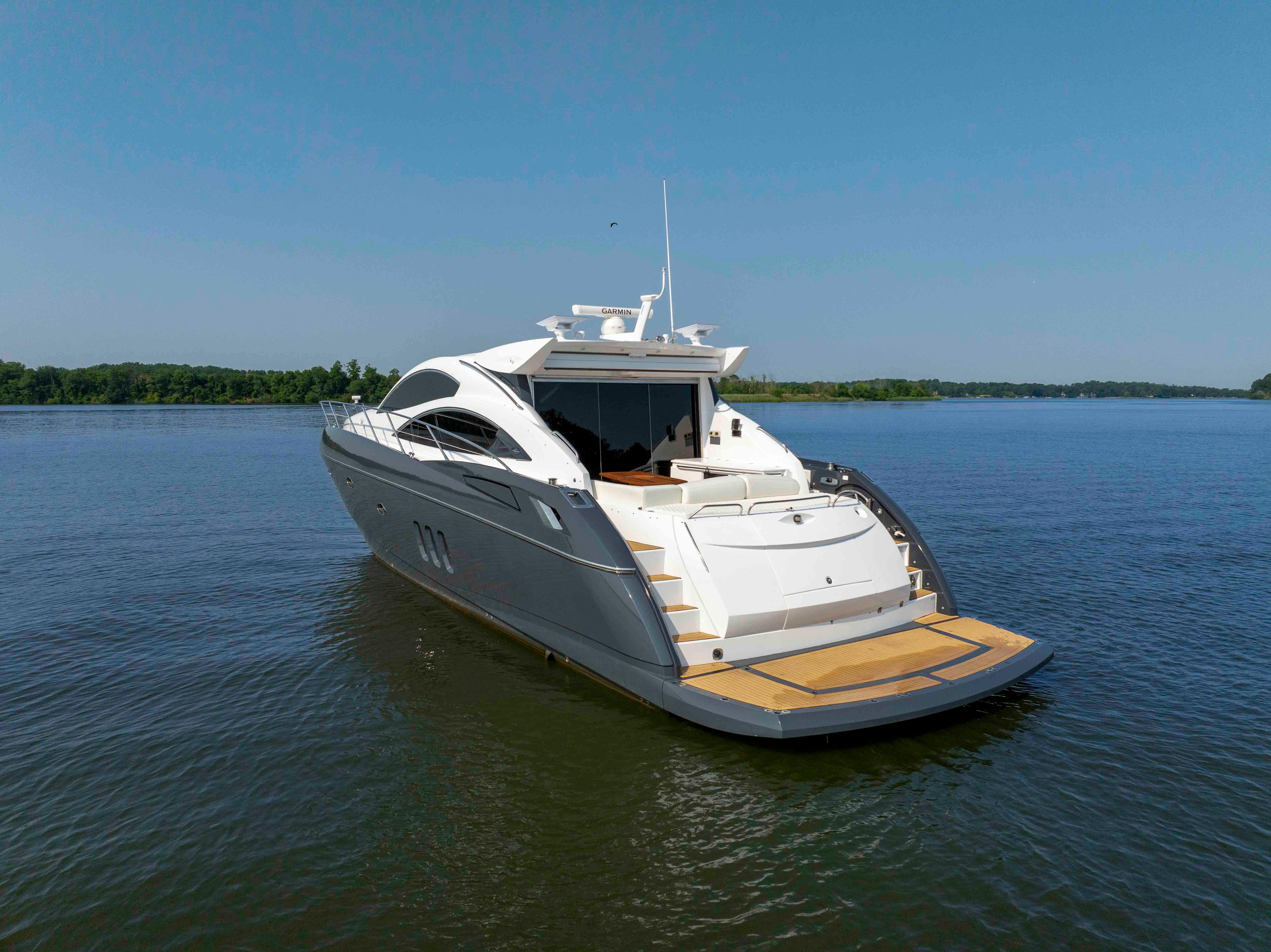 2009 Sunseeker Predator 62 yacht on calm water, clear sky background.