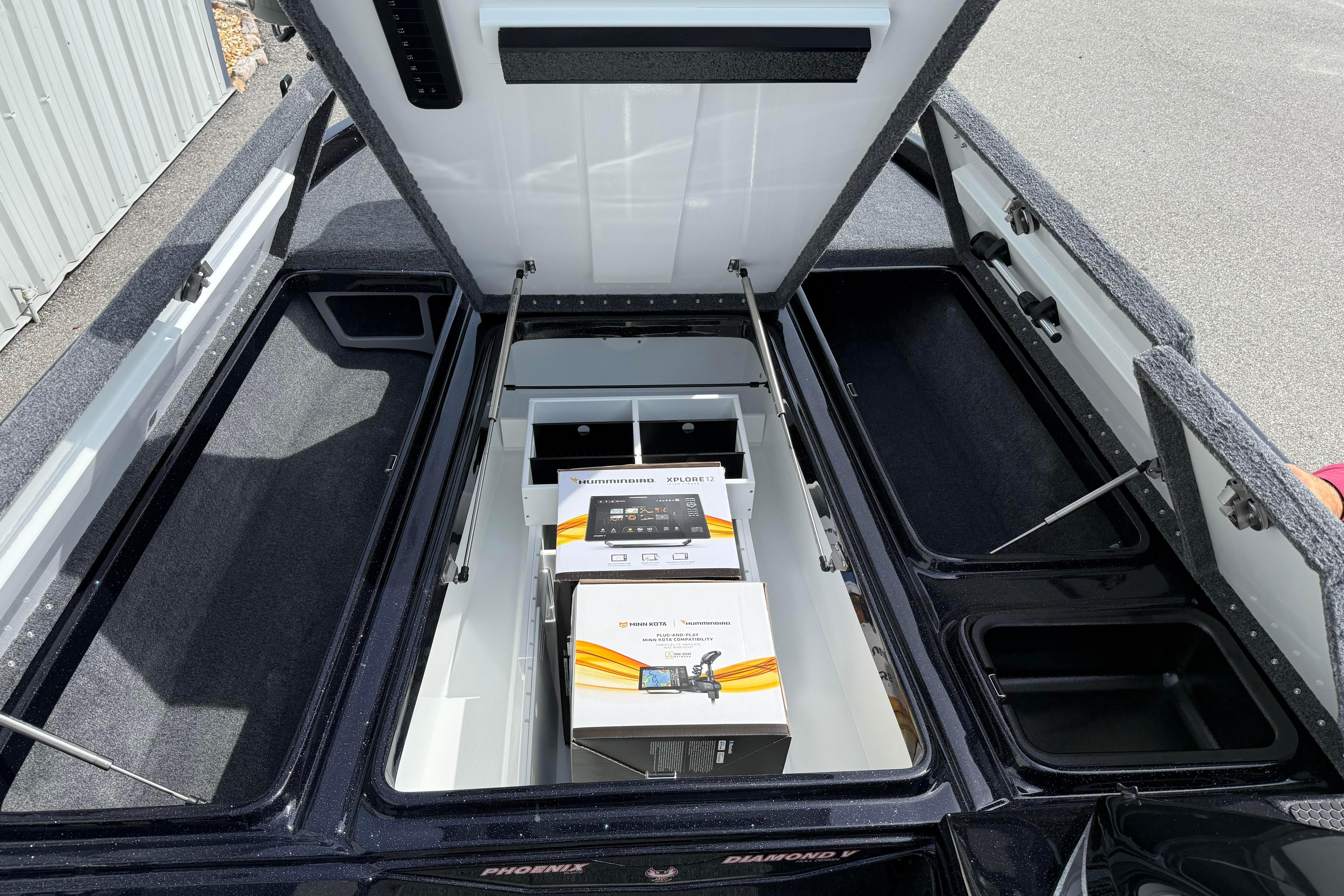Open storage compartments in a 2027 Phoenix 921 Elite X boat, showcasing organized interior space.