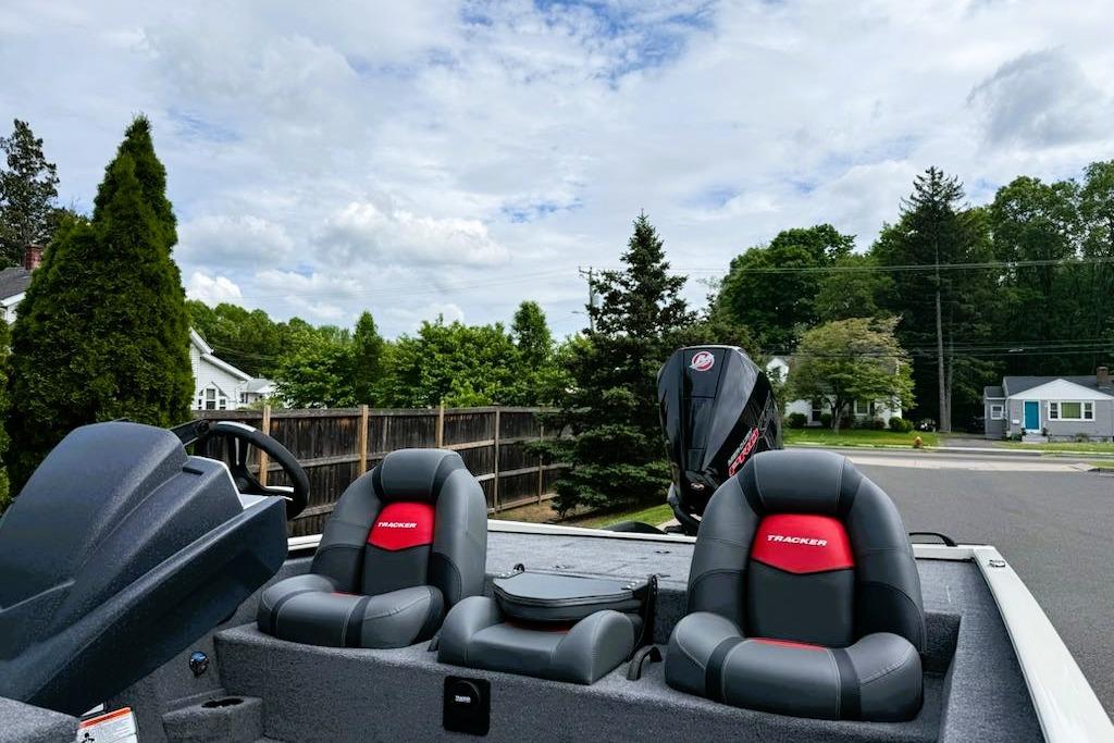 2025 Tracker Savage 215 boat with dual seats and motor, parked in suburban area.