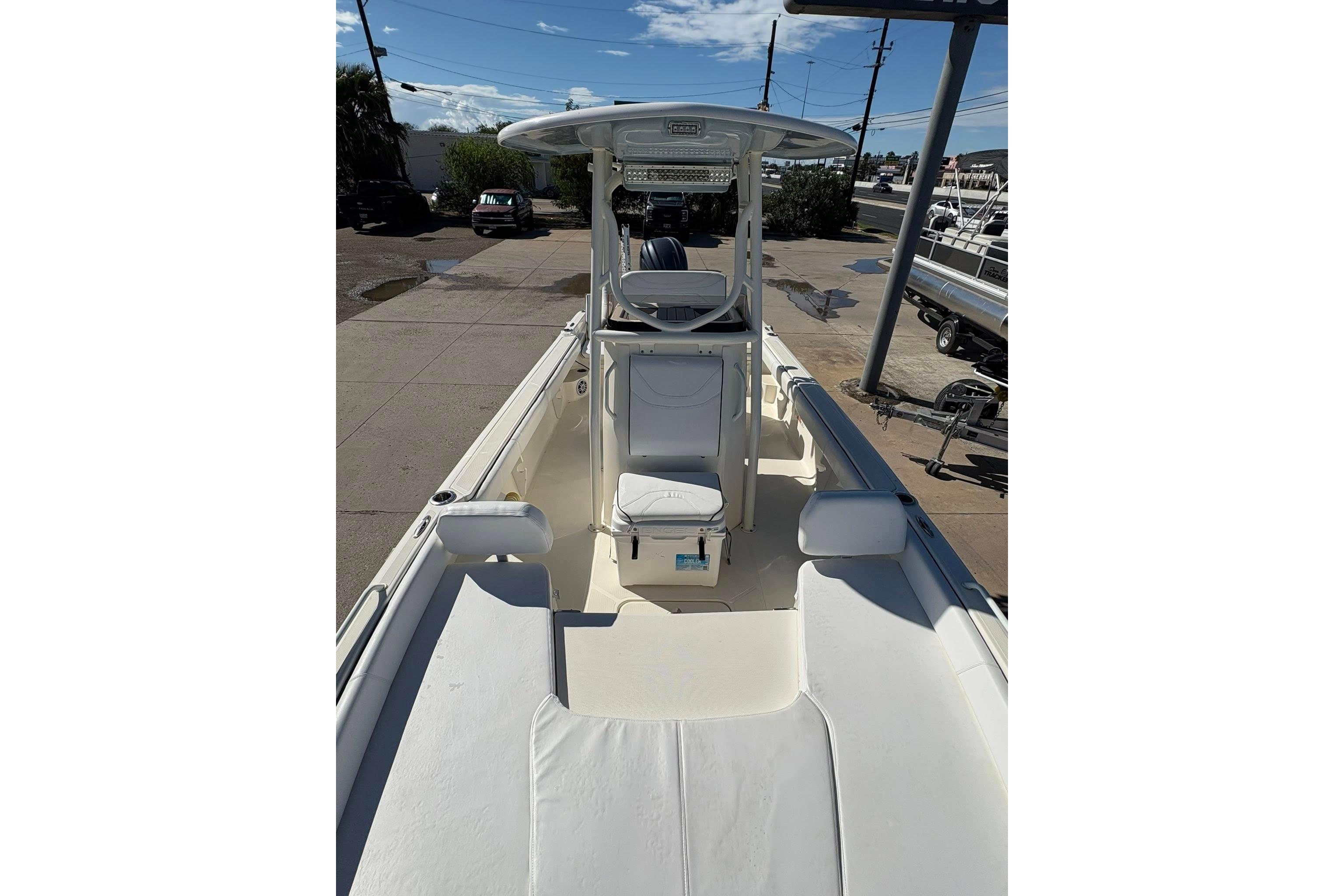 2023 Skeeter SX2550 Family boat, spacious deck, white seating, clear sky background.
