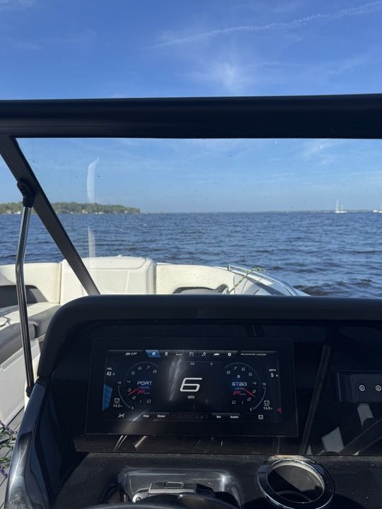 View from the cockpit of a Yamaha 212SD boat, showing water and a digital dashboard.