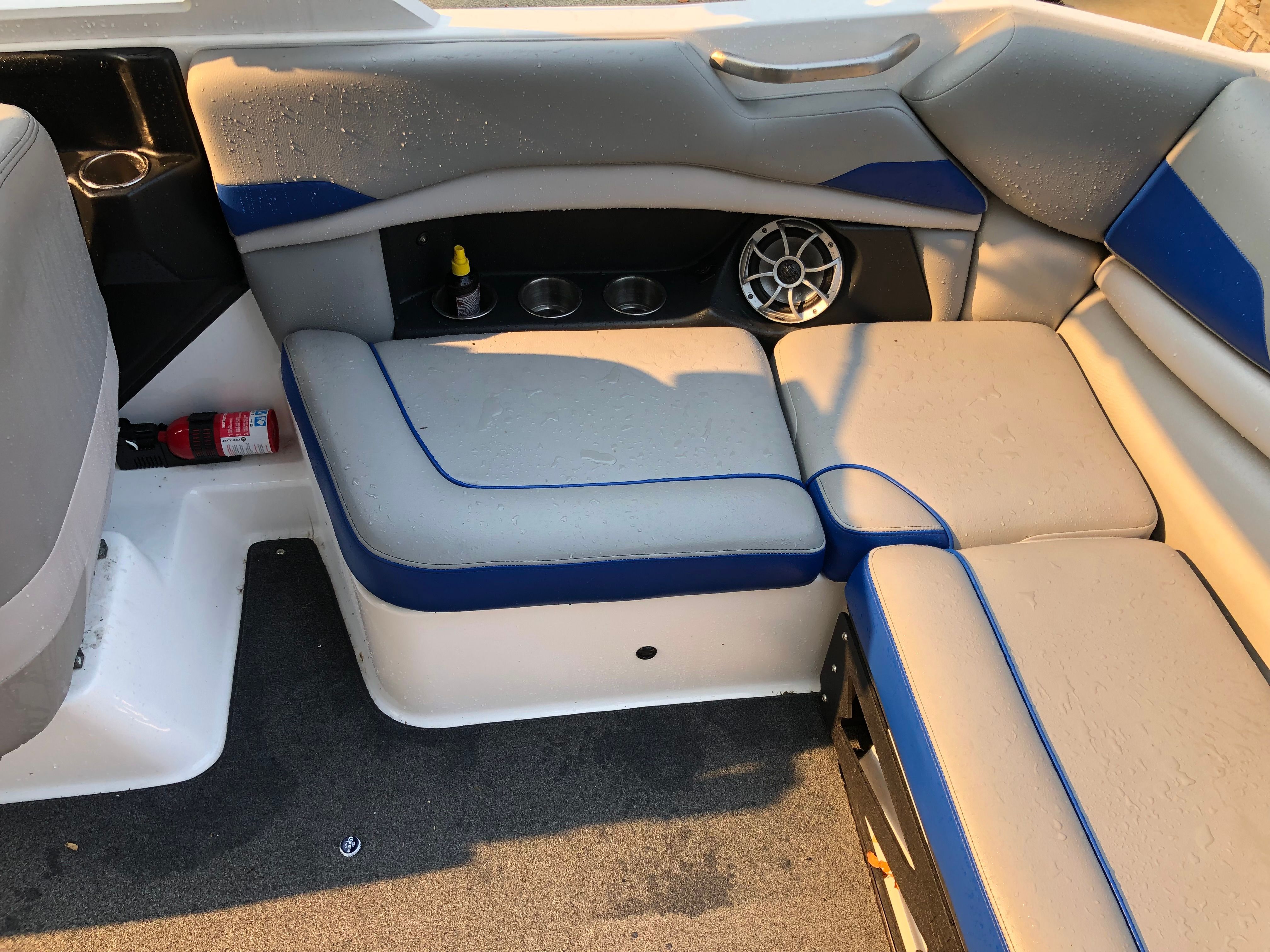 Interior of Custom a22 boat, gray and blue upholstery, speaker, fire extinguisher.