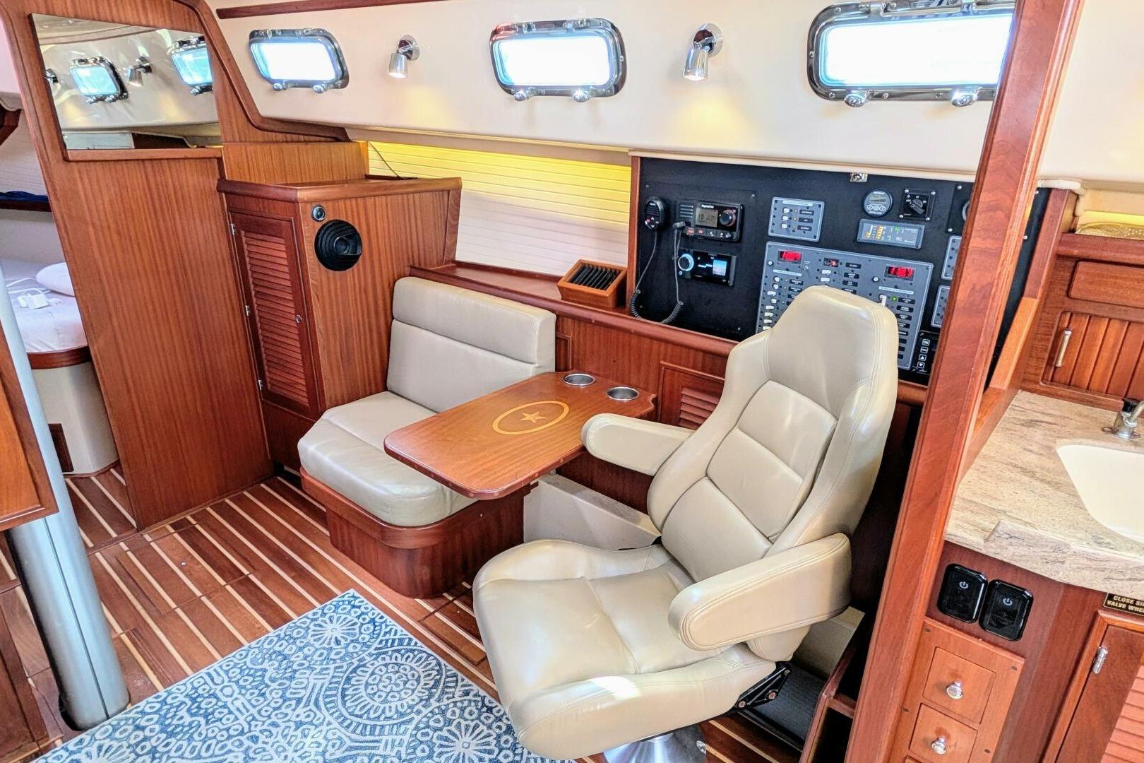 Interior of 1999 Island Packet 349 yacht with navigation station and seating area.