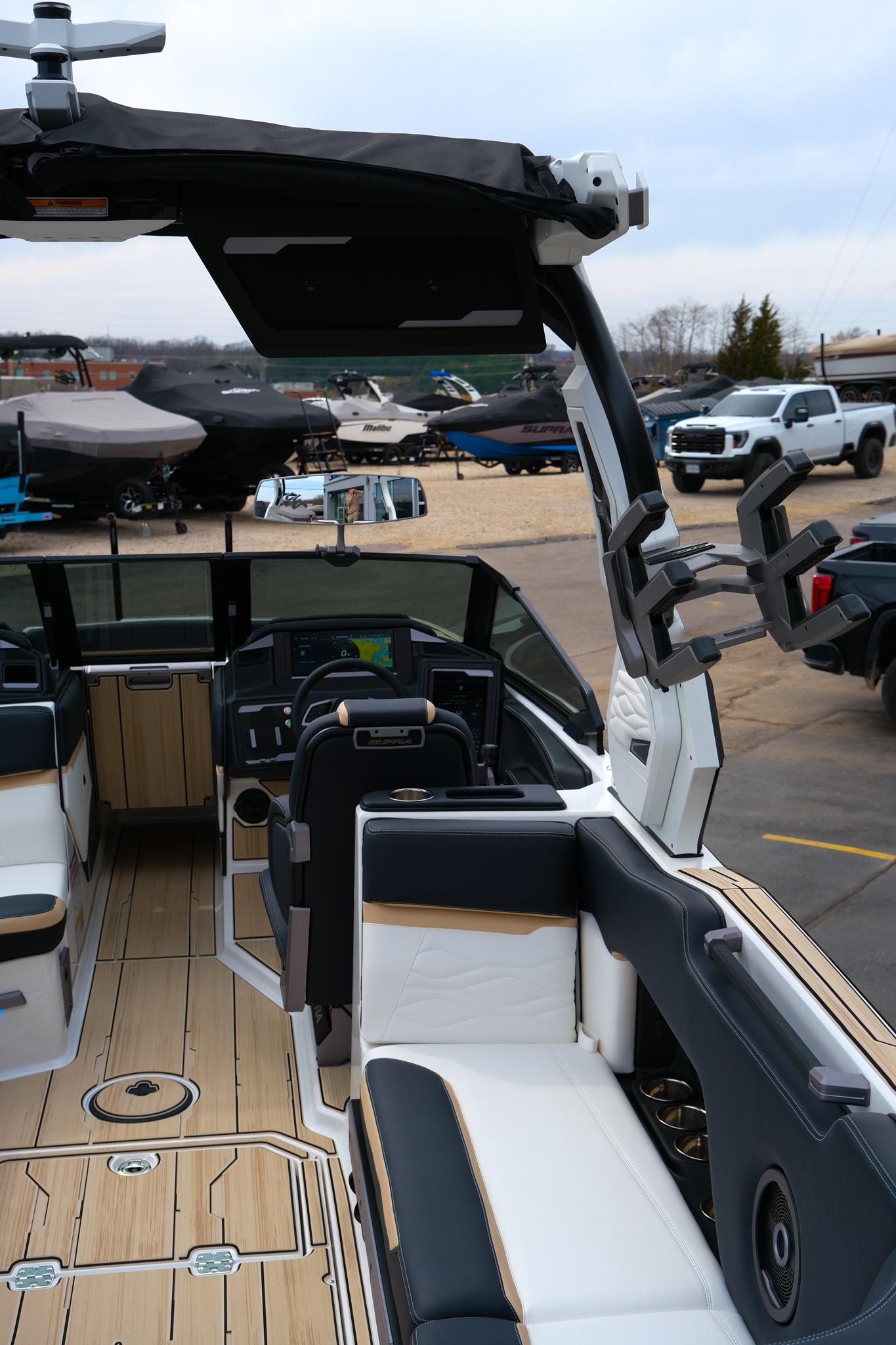 2025 Supra SE450 boat interior with modern seating and dashboard, docked outdoors.