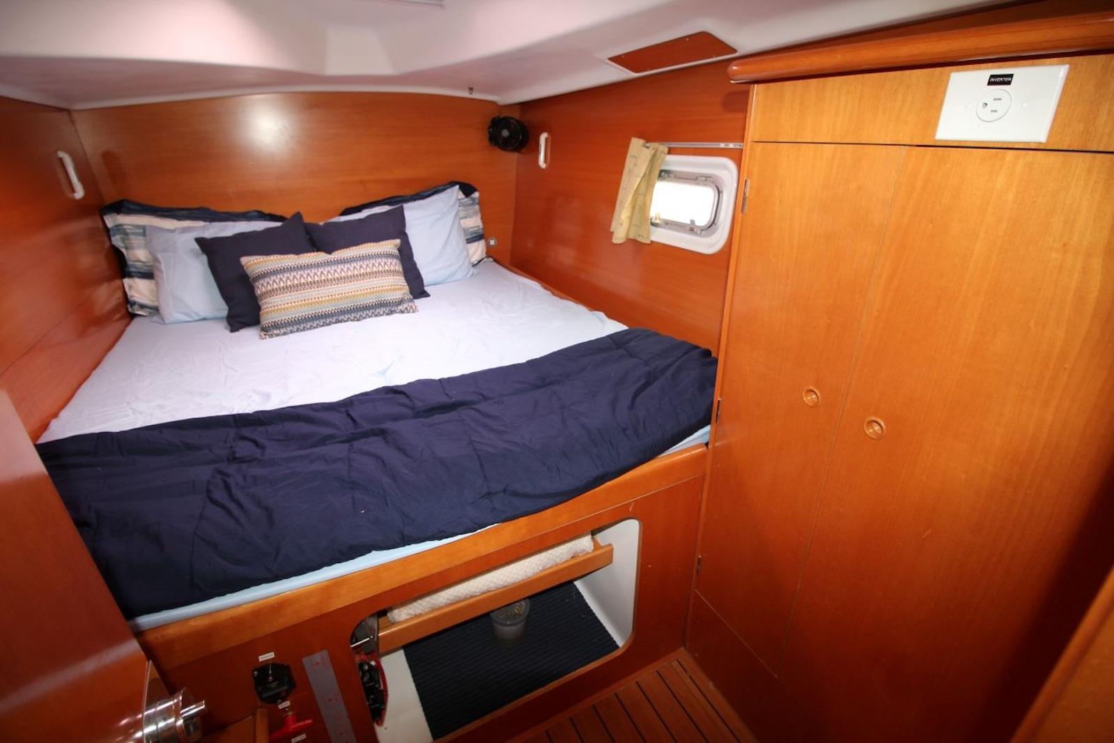 Cozy cabin interior of 2004 Lagoon 380 catamaran with wooden finish and comfortable bedding.