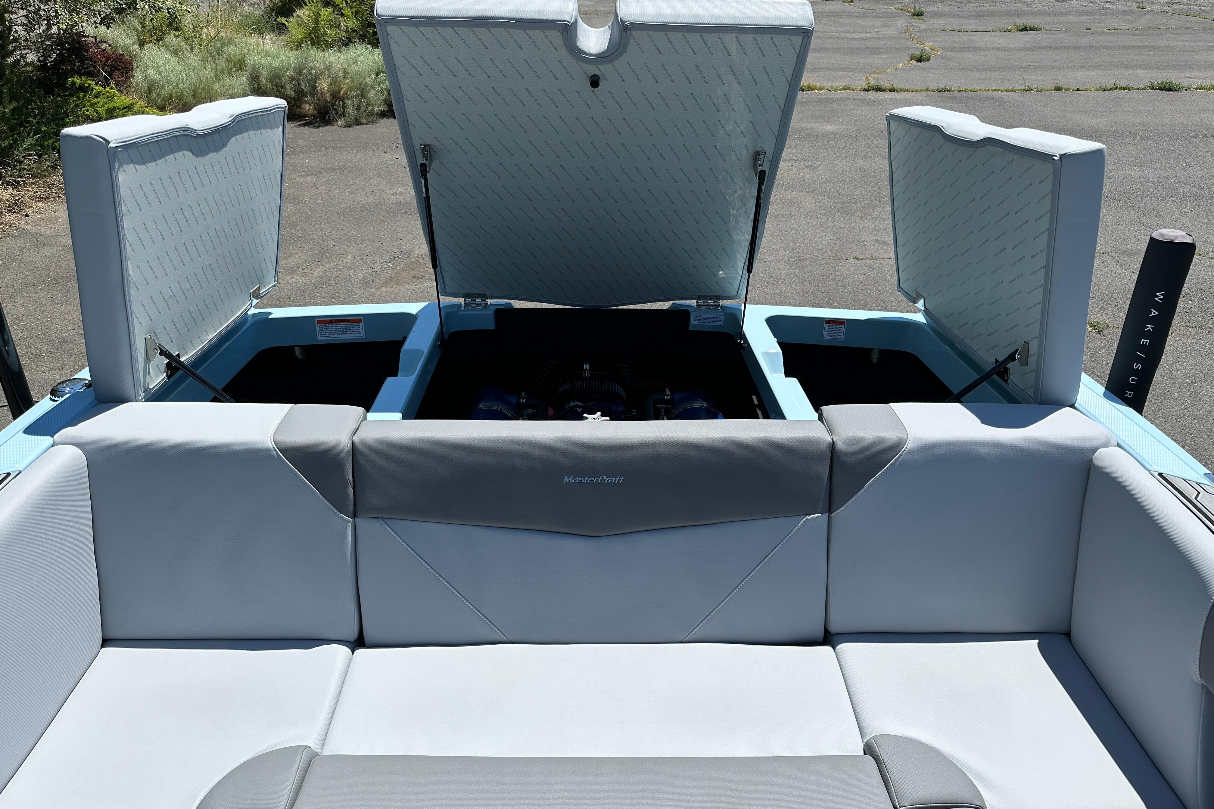 2023 MasterCraft NXT23 boat interior with open storage compartments and cushioned seating.